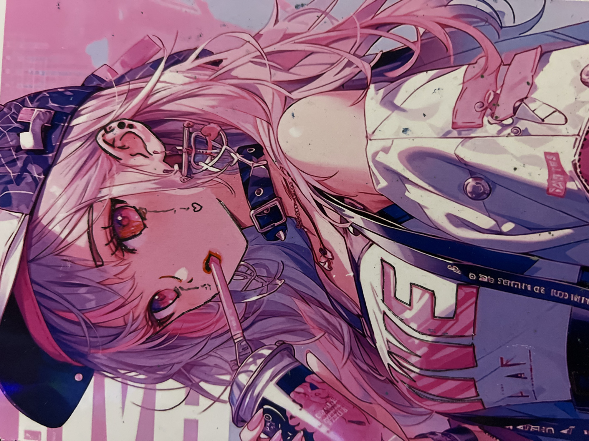 This is a close-up, angled, medium shot of an anime-style illustration of a young woman. She has long, wavy pink hair, large red eyes with black pupils and dramatic eyelashes, and a small, red-lipped mouth. She is wearing a black baseball cap with a pink band and a dark, patterned design on the front. A pink straw extends from her lips, through which she appears to be drinking from a pink can with a white and blue label. She is wearing a black choker with a silver buckle and a silver hoop earring with a dangling charm. Her clothing consists of a white jacket with pink accents, worn over a white tank top with the word "LIFE" printed in large pink letters. Her left shoulder is visible, and her skin is rendered with soft shading. The background is an abstract wash of pink and white. There is no identifiable urban environment or location in Minsk, Belarus.