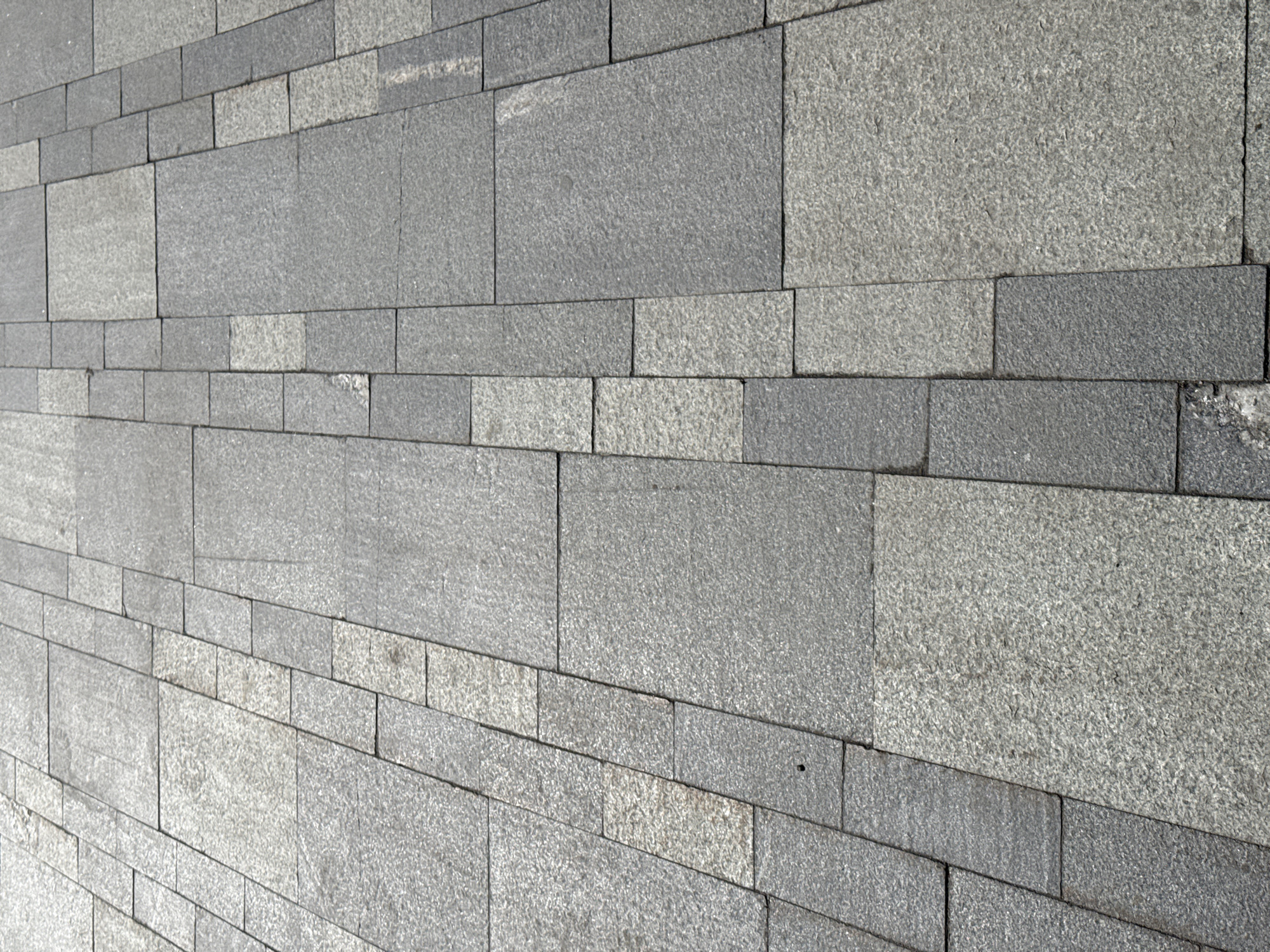 The image shows a gray stone wall in a brick-like pattern. The stones have varying textures and shades of gray. The perspective is slightly angled, creating a sense of depth. The location is Perm, Russia.