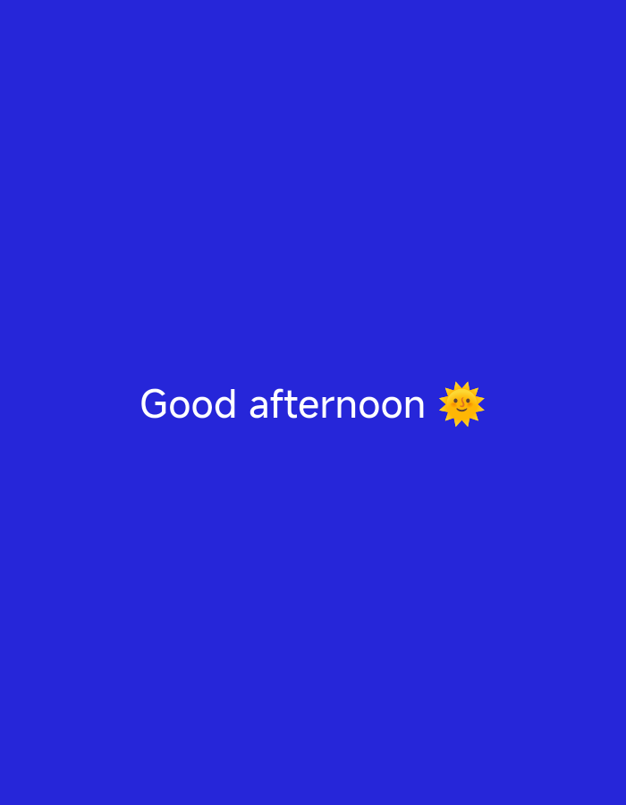 The image features a solid, vibrant blue background. Centered horizontally and slightly below the vertical midline of the image, white text reads "Good afternoon". Immediately following the text is a yellow sun emoji, depicted with a smiling face and radiating rays. There are no other visible subjects, objects, or activities in the image. The time of day suggested by the text and emoji is afternoon, likely indicating a pleasant, sunny atmosphere. There are no discernible location cues within the image itself.