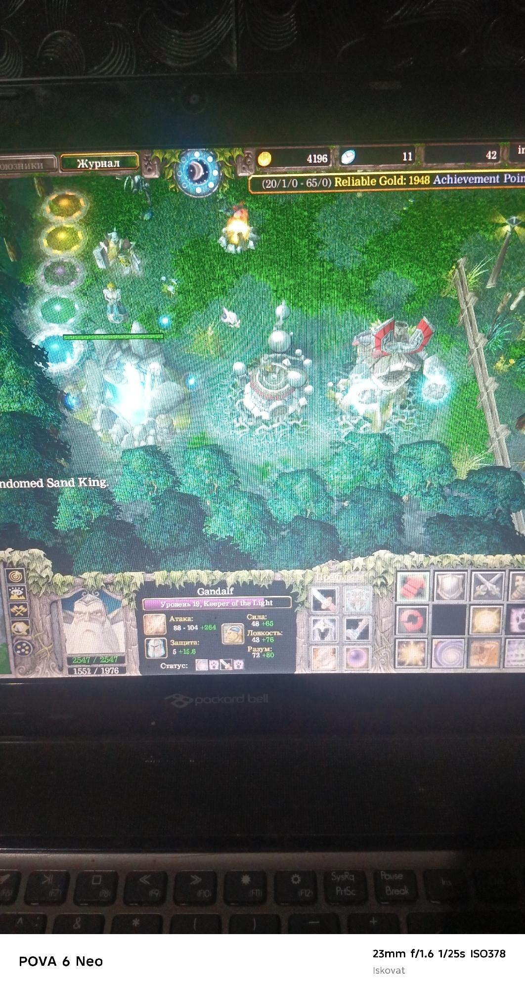 The image shows a close-up of a laptop screen displaying a real-time strategy game. The game interface is visible at the bottom, showing character stats for "Gandalf, Level 19, Keeper of the Light," including attack, defense, strength, agility, and intelligence. Resource counters are visible at the top of the screen, showing 4196 gold and 11 lumber. The in-game environment depicts a lush green forest with trees and structures. Below the laptop screen, a portion of the keyboard is visible, along with the branding "POVA 6 Neo" and camera settings "23mm f/1.6 1/25s ISO378". The scene is forensic and matter-of-fact, focusing on the details presented on the screen and the device. The location is described as Pastki-Peshkurgan, Uzbekistan.