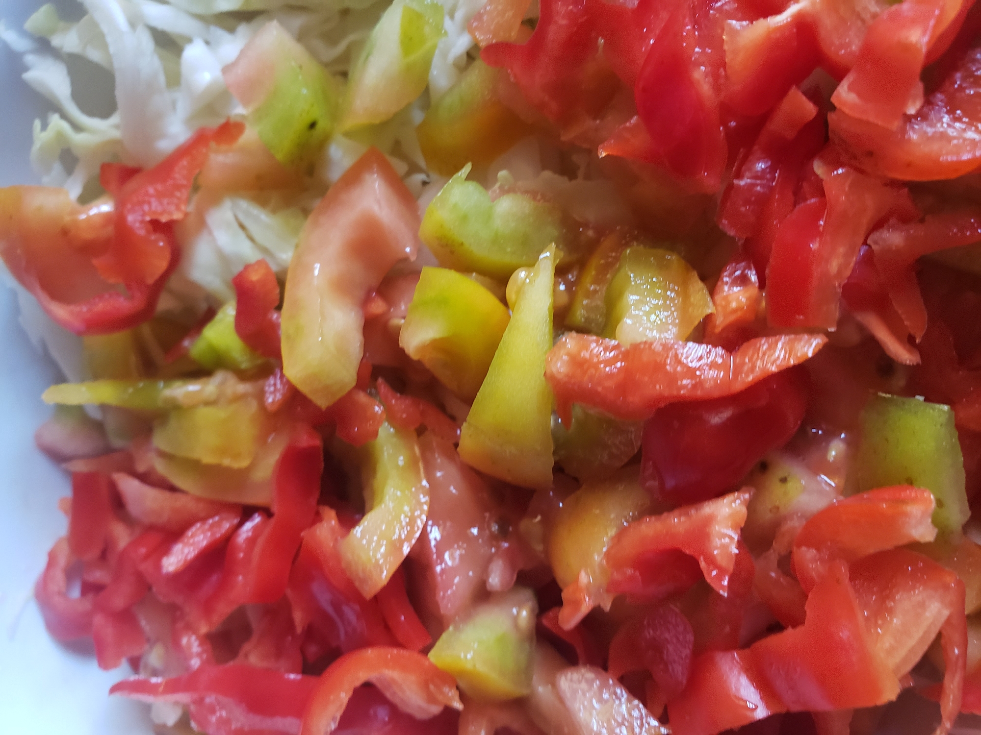 The image shows a close-up view of a chopped salad in a white bowl. The salad consists primarily of chopped red bell peppers and chopped tomatoes, with some finely shredded white cabbage visible in the background. The vegetables appear fresh and moist, suggesting they have been recently prepared. There are no people or any other objects visible in the image besides the salad and the bowl. The image does not provide any information about the location in the city of Narayi, Nigeria.