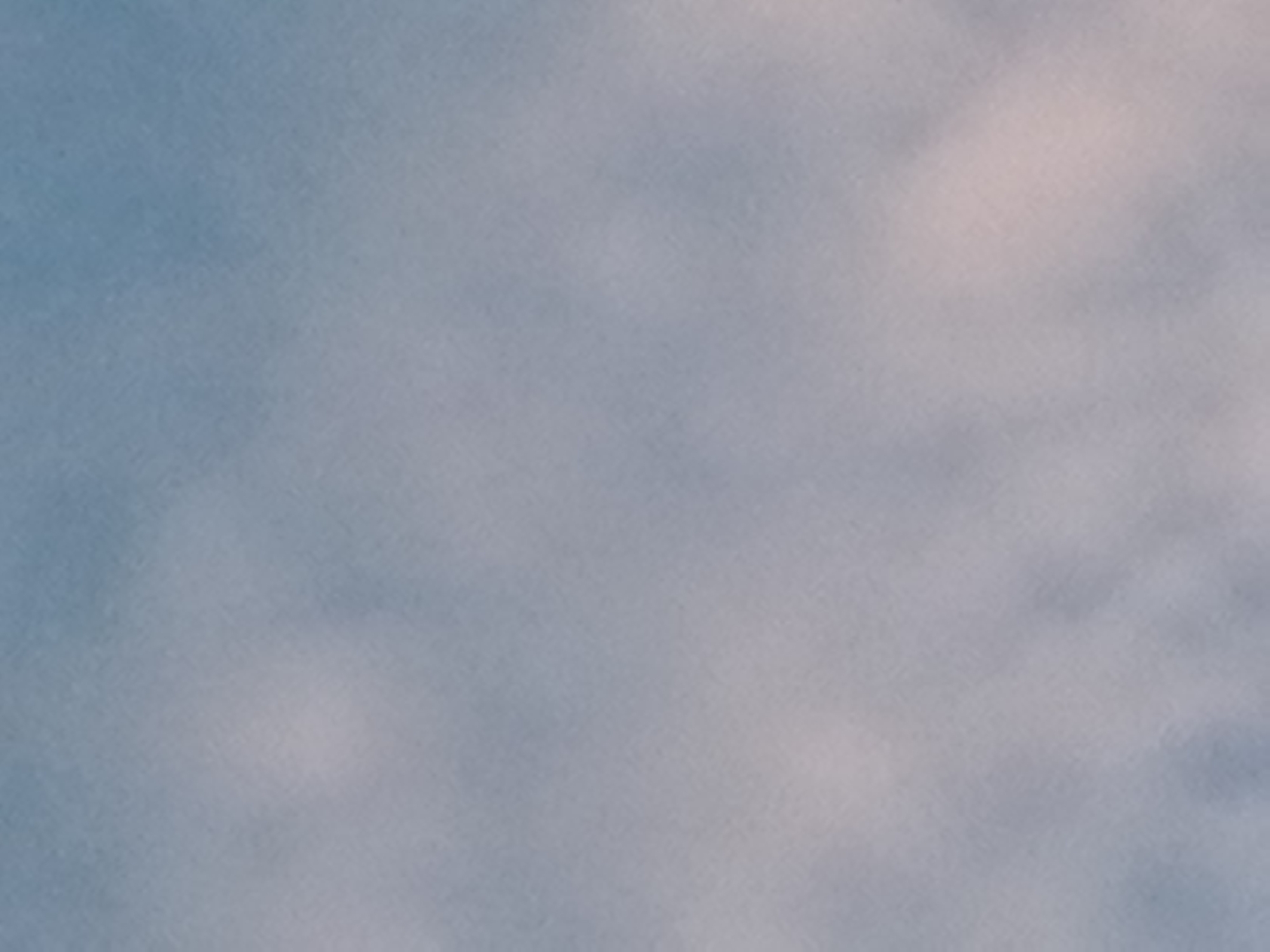 The image shows a sky with clouds. The colors are mainly blue and white. There are no identifiable objects or people in the frame. The texture appears soft and diffused, consistent with a sky scene. The image provides no information to identify the location in Lhokseumawe, Indonesia.