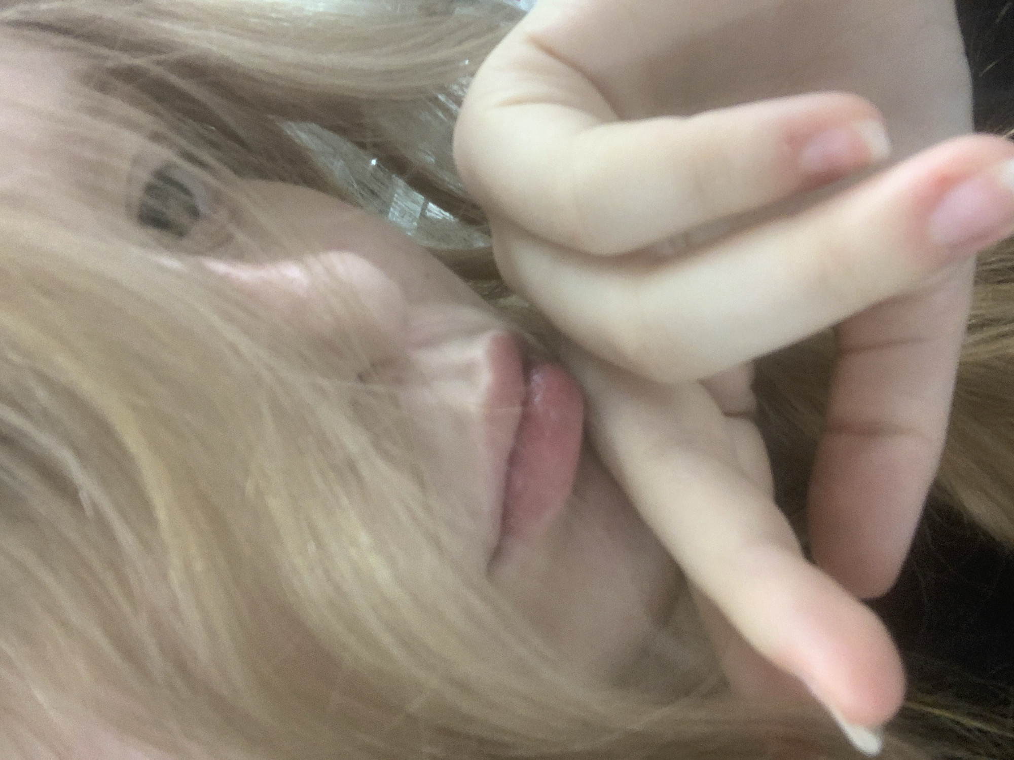 A close-up, tilted image of a fair-skinned person with light blonde hair. A hand, also fair-skinned, is positioned near their face. The image focuses on the person's eye, mouth, and the fingers of the hand. No information connects this image to Saint Petersburg, Russia.