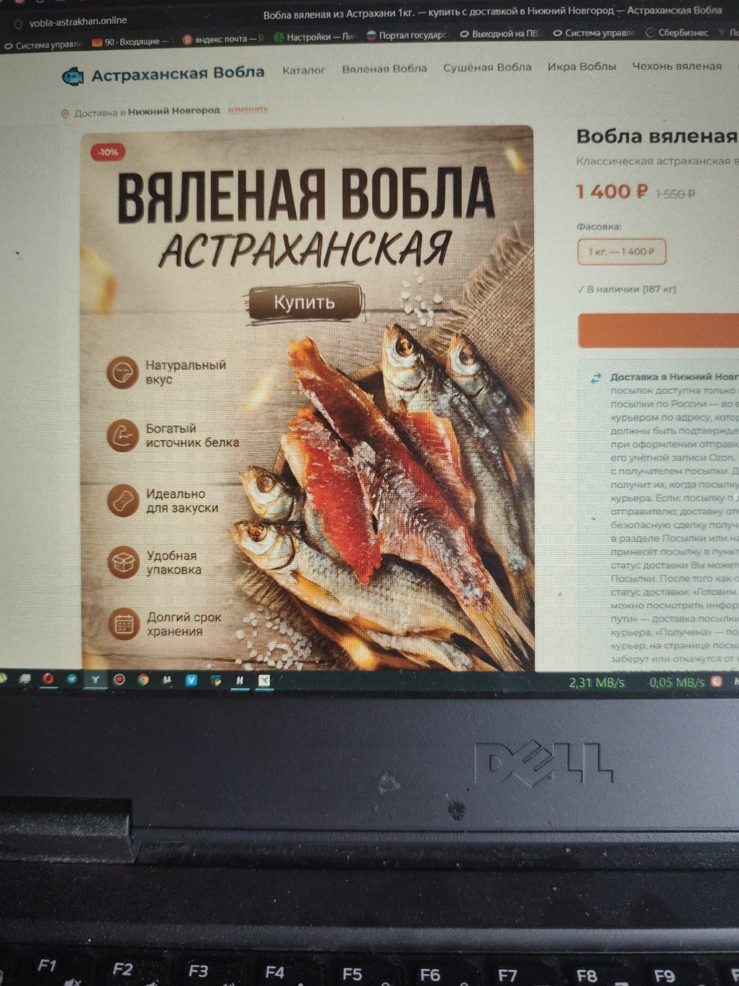 The image displays a screenshot of a website on a laptop. The website appears to be an online store selling "Astrakhan dried fish" (Вобла астраханская). The main product featured is "Dried Astrakhan Vobla" with a price of 1400 rubles per kilogram. Several benefits of the product are listed, such as "Natural taste," "Rich source of protein," "Ideal for snacks," "Convenient packaging," and "Long shelf life." There's also information about delivery to Nizhny Novgorod, with details about the shipping process. The bottom of the image shows a portion of a black Dell laptop keyboard. The image does not provide any information about the city of Bor, Russia.