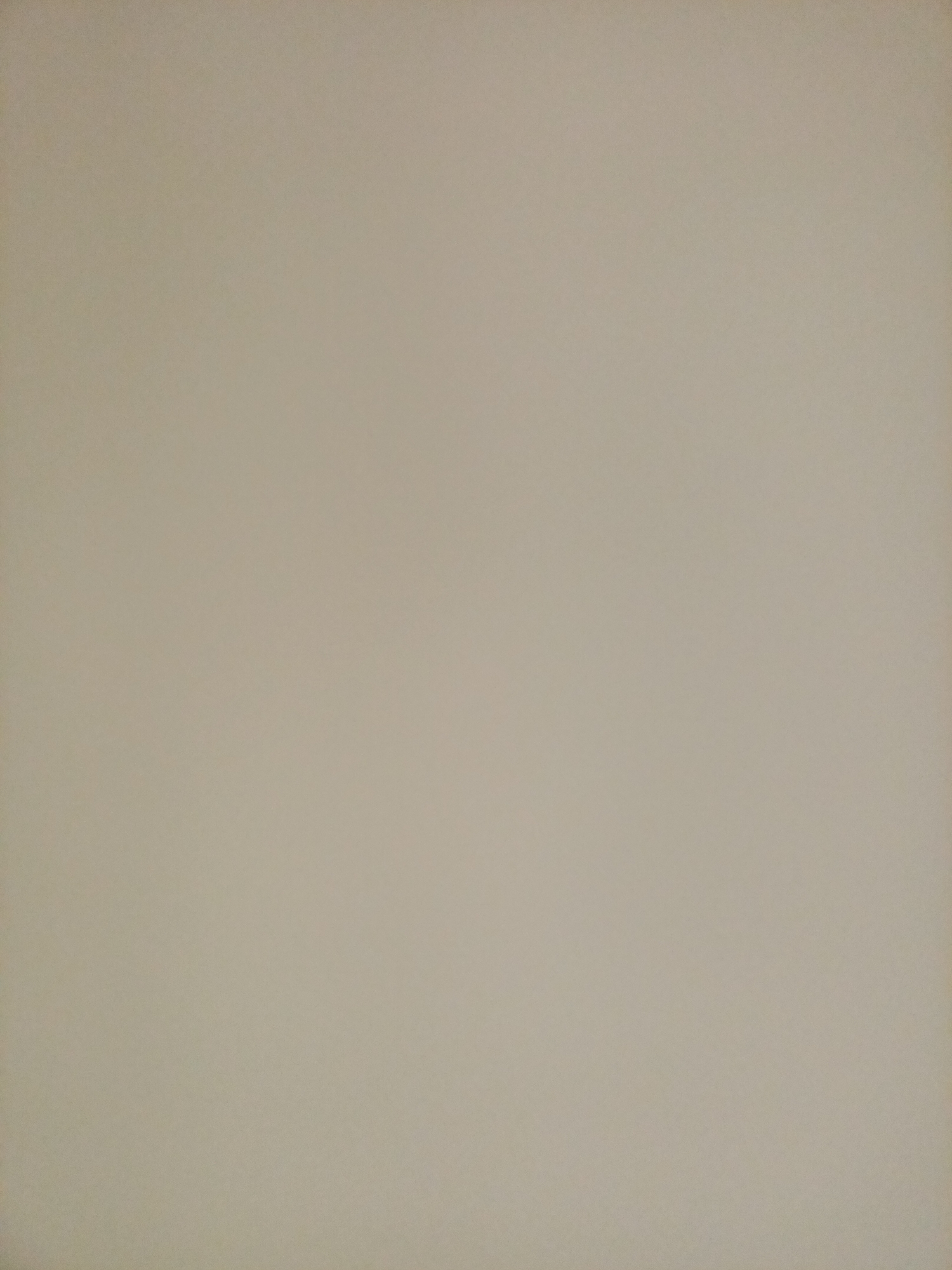 The image is a close-up, full-frame, overhead shot of a blank, beige wall. There are no visible objects, people, or distinguishing features within the frame. The lighting is even, with no shadows or highlights. The wall appears to be textured, with a subtle, grainy pattern visible upon close inspection. No specific location in Rostov-on-Don, Russia can be identified from this image.