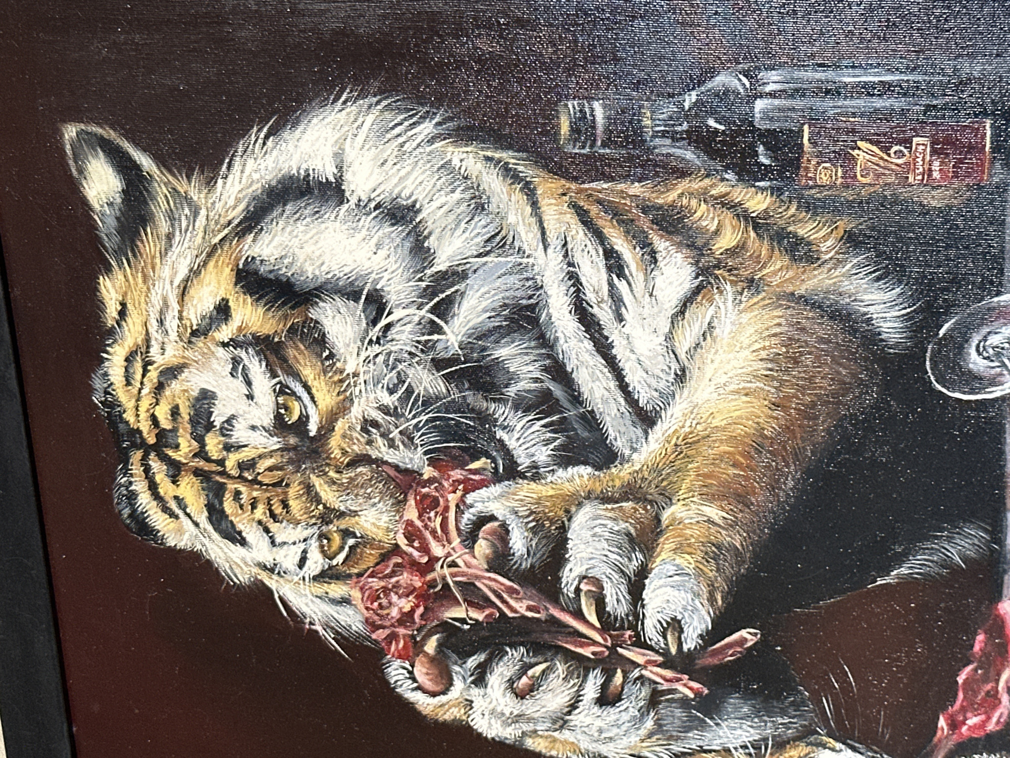 This is a realistic painting depicting a tiger in the process of eating raw meat. The tiger is positioned in the center of the frame, with its head tilted down as it holds a piece of meat in its paws. The meat appears to be red and bloody, with some bone visible. The tiger's fur is rendered in detail, showing its characteristic orange, black, and white stripes. Its eyes are bright yellow and appear to be focused on the meat. To the right of the tiger, there is a dark glass bottle with a label that appears to have the number "76" on it, and the word "TEQUILA" is visible. There is also a partially visible wine glass in the foreground. The background is a dark, muted reddish-brown color, with some subtle texture suggesting a canvas. The scene appears to be indoors, possibly a studio or a dimly lit room, with no identifiable city or outdoor elements.