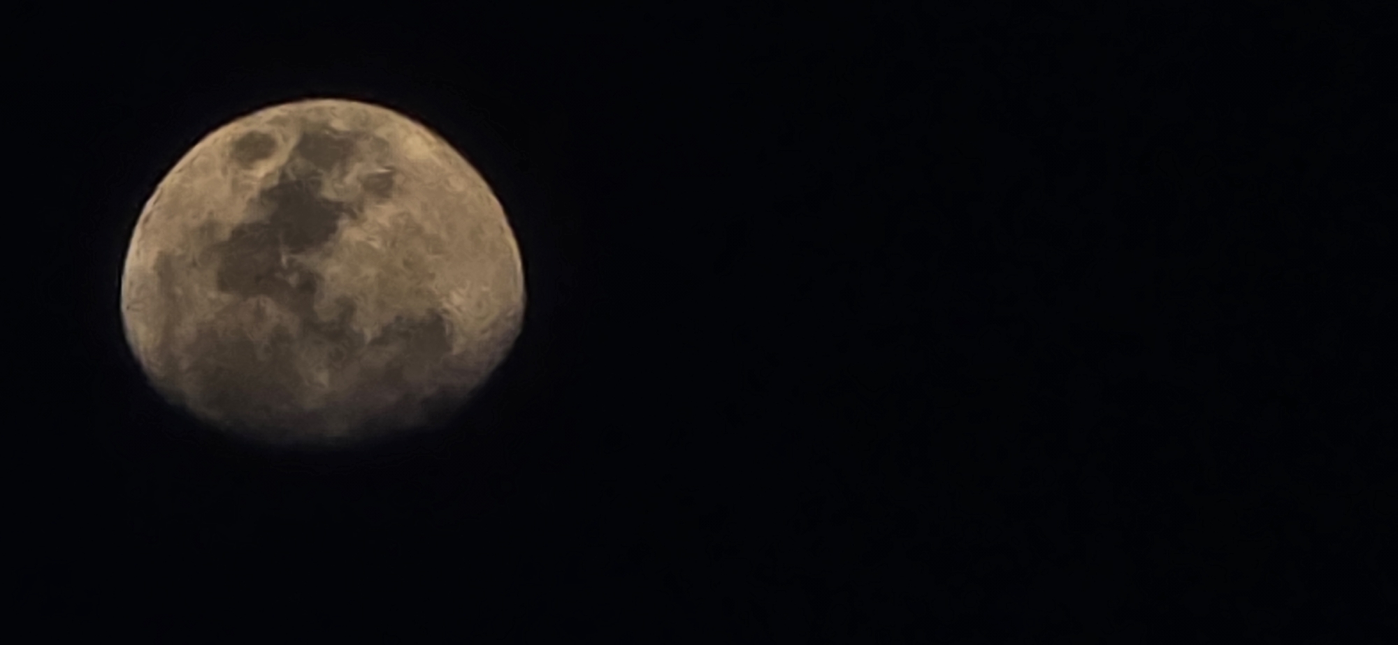 A low-quality, dark image shows a portion of the moon against a black sky. The moon is illuminated from the right, with shadows and craters visible on its surface. The image is vertically oriented and the moon is positioned in the upper half of the frame, taking up approximately one-third of the width. The lower two-thirds of the image are completely black, indicating a lack of light or an absence of any other discernible objects. There are no people, buildings, or any other elements that would suggest a specific location within the city of Mazyr, Belarus, or any other identifiable place. The overall impression is a simple astronomical photograph.