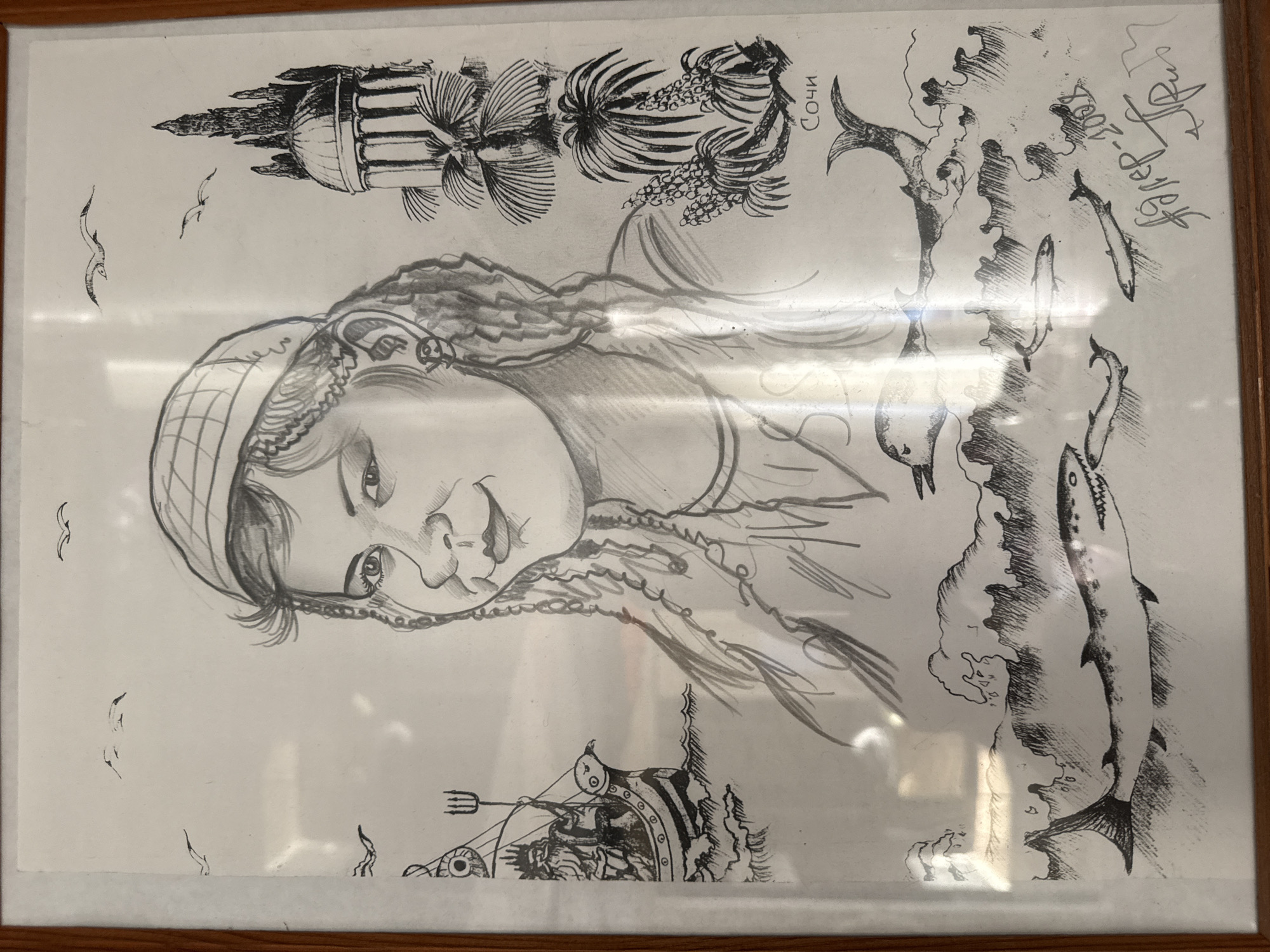 The image depicts a framed black and white sketch on paper. A portrait of a woman with a cap is the central figure. Above her, there is an architectural structure resembling a building with columns and palm trees. A scene with a fish and coastline is to the right of the woman’s portrait. The name "Сочи" (Sochi) is written near the coastline depiction. Below the woman's portrait, there is a drawing of a carriage being pulled through water, with a trident-like object present. There are sketches of birds in the upper left corner. The date "12 Sep 2004 Чайковский" (Chaikovsky) is scrawled in the upper right corner, suggesting the location is the city of Chaikovsky, Russia. The artist's signature is also present.