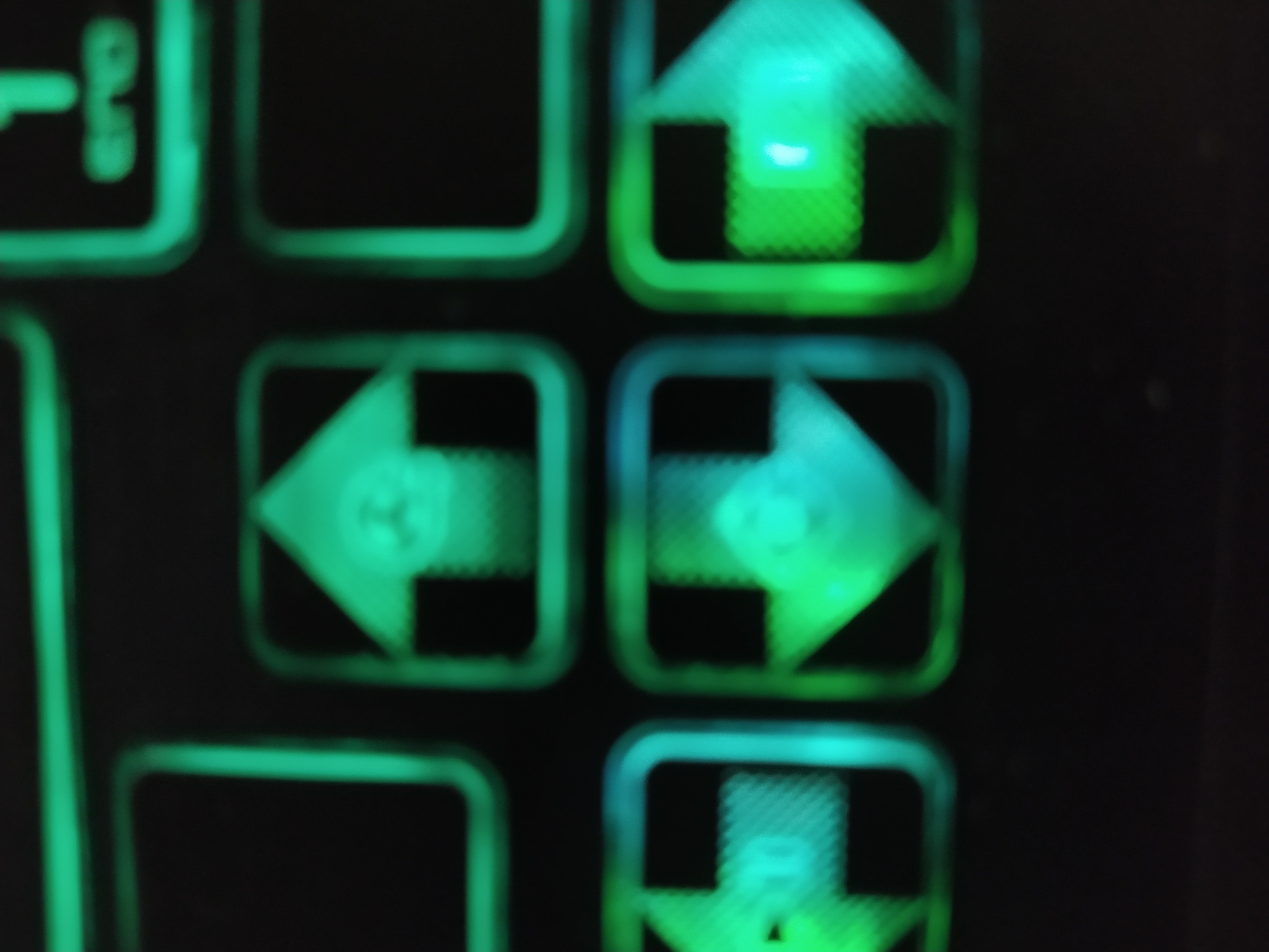 The image shows a close-up of illuminated arrow keys on a keyboard. The arrows are arranged in a typical configuration: up arrow on top, left arrow to the left, right arrow to the right, and potentially a down arrow below. The illumination is green and/or blue. The image is blurry and lacks specific information that would permit the location in Sofia, Bulgaria.