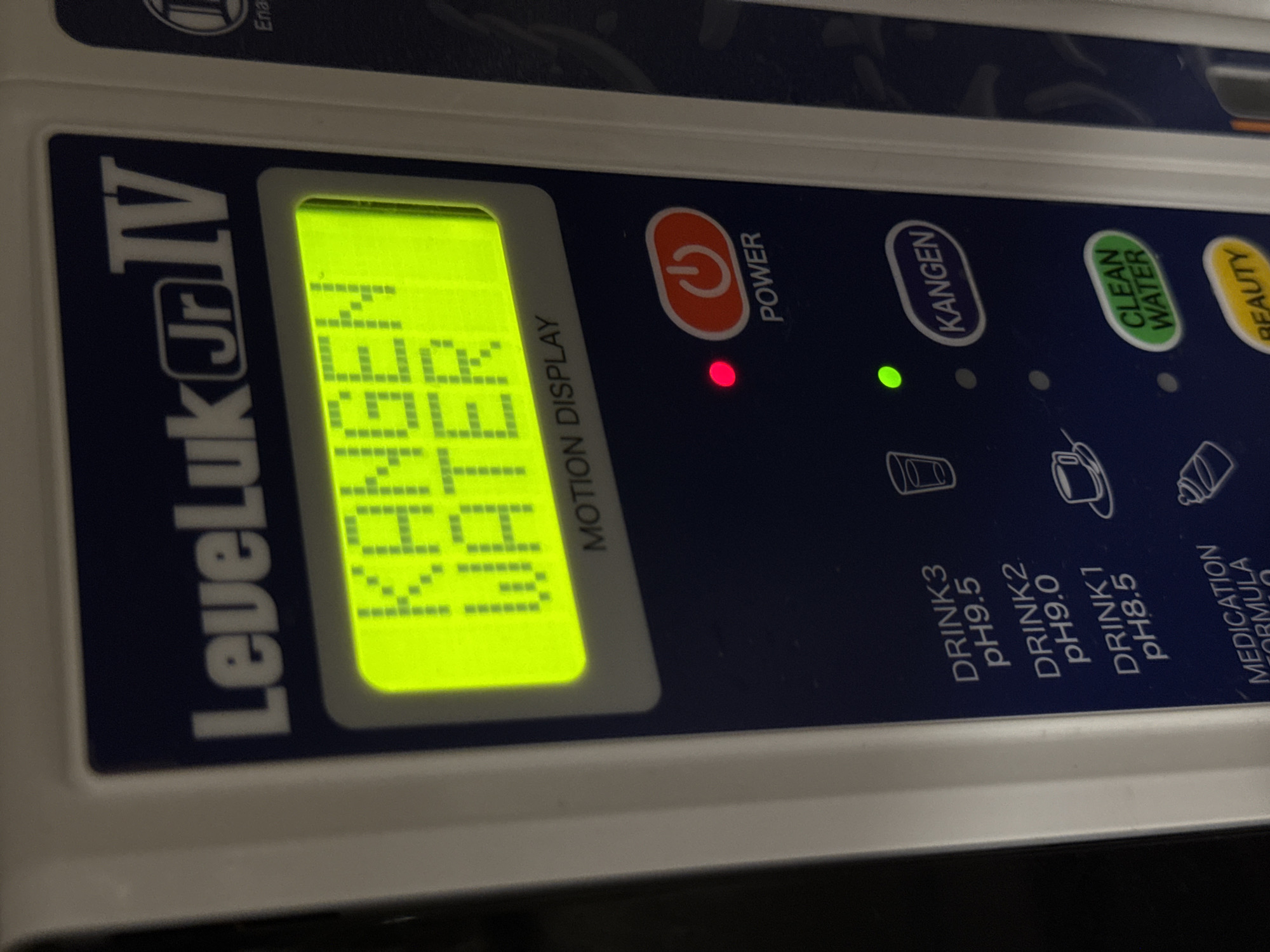 The image shows the control panel of a LeveLuk Jr IV water ionizer. The display indicates "KANGEN WATER". Buttons for power, Kangen, Clean Water, and Beauty are visible. The power button has a red light illuminated, and the Kangen button has a green light illuminated. Below, icons and text indicate options for "DRINK3 pH9.5," "DRINK2 pH9.0," "DRINK 1 pH8.5," and "MEDICATION FORMULA." The scene does not offer any forensic indicators as to the geographic location of Kazan, Russia, or the presence of any people.
