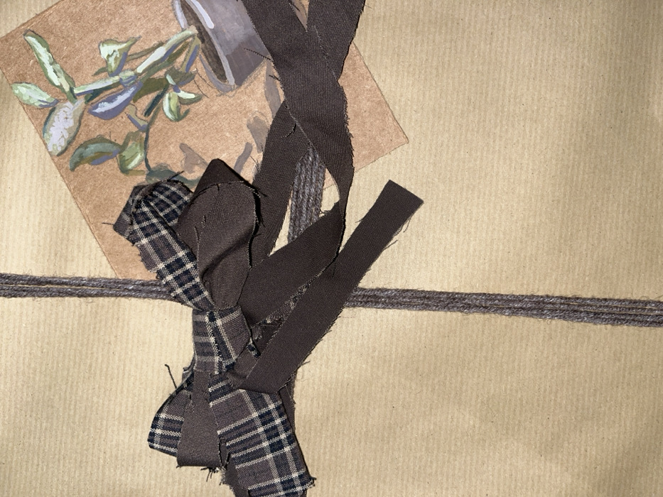 The image presents a close-up, overhead view of what appears to be a gift or package wrapped in natural brown kraft paper. The wrapping paper exhibits a subtle, uniform vertical ribbed texture throughout.
A triple strand of dark gray or deep brown twine is wrapped horizontally across the package, creating a distinct line in the lower middle section of the frame. The twine has a slightly fuzzy texture, indicating it is likely made of a natural fiber.
In the upper left quadrant, a small, roughly square piece of light brown cardstock or thick paper is placed on top of the wrapping paper, angled slightly towards the left. This cardstock features a painted illustration of a potted plant. The plant has several light green leaves with hints of bluish-purple, possibly depicting a succulent or a similar indoor plant. It is shown in a simple, gray cylindrical pot. The painting style appears to be watercolor or gouache, characterized by visible brushstrokes and a somewhat illustrative quality. The light brown of the cardstock serves as the background for the painted elements.
Overlapping the horizontal twine and the lower right corner of the painted cardstock, a decorative cluster of fabric pieces is arranged, resembling a rustic, deconstructed bow or embellishment. This cluster incorporates two different types of fabric:
1. A piece of dark brown/black and cream plaid fabric, which forms the central knot and some loops of the bow. This fabric shows a clear woven texture and has deliberately frayed, raw edges, contributing to a handmade aesthetic.
2. Several strips of a solid, dark, earthy brown fabric, likely cotton or linen. These strips are intertwined with the plaid fabric and also feature frayed, unfinished edges. Some strips extend upwards and to the right, adding a dynamic and unpolished touch to the arrangement.
The overall impression is one of a carefully, yet naturally and handcrafted, adorned package, suggesting a thoughtful and personalized presentation. The lighting is soft and even, highlighting the textures of the various materials. There are no people, visible text, or specific location/time details discernible in the image.
