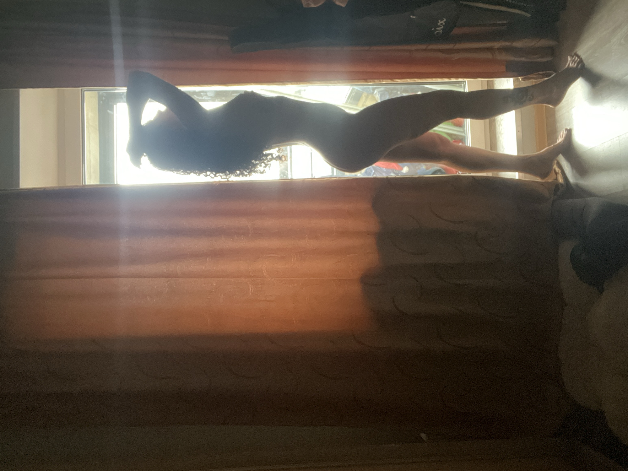 The image shows a silhouetted nude woman posed in a window. The window is partially obscured by curtains. The specific location in Saint Petersburg, Russia cannot be determined from the image.