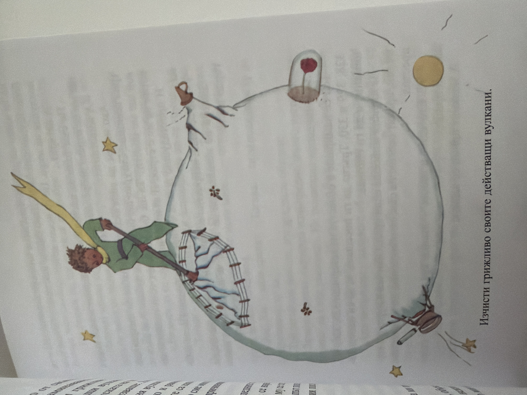 The image shows an illustration from a book. In the center, a small boy with brown hair and a yellow scarf is depicted wearing a green outfit. He is standing on a spherical object, which appears to be a planet, and is using a shovel to clear something from its surface. There are several small, brown, star-like shapes scattered on the planet, and a few more in the background. One prominent element is a glass-like tube containing a red object, possibly a flower, protruding from the side of the planet. There are also some wires and fencing-like structures on the planet. The planet itself is drawn as a pale, translucent sphere. In the bottom right corner of the illustration, there is text in Bulgarian.
The location in Pazardzhik, Bulgaria is not determinable from the provided image.