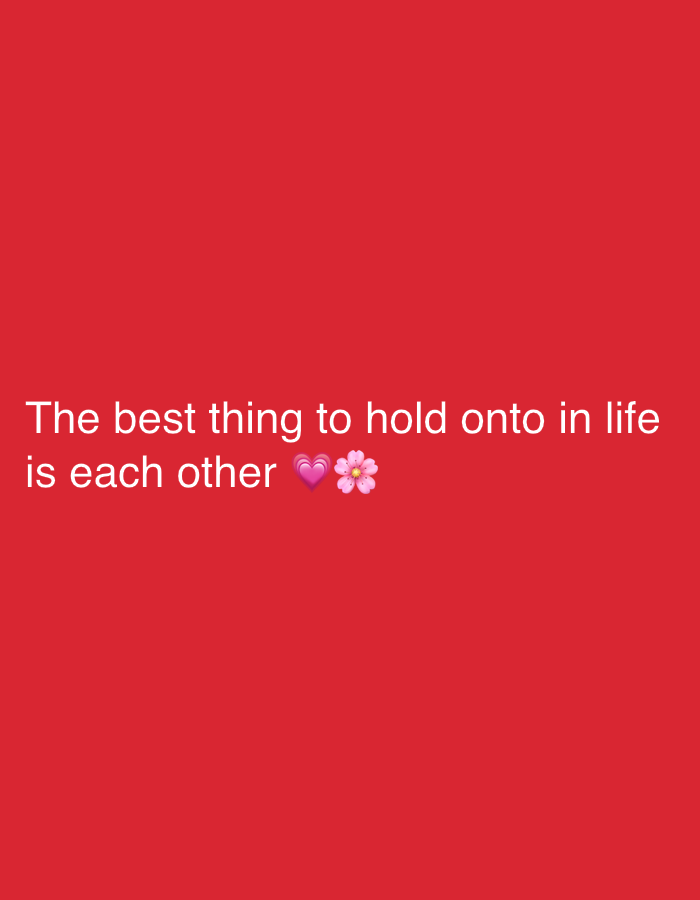 A graphic featuring white text and two emojis is displayed against a solid red background. The text, presented in a sans-serif typeface, reads: "The best thing to hold onto in life is each other". Immediately following the text are a pink heart emoji (💖) and a cherry blossom flower emoji (🌸). The textual content and emojis are horizontally centered and positioned in the lower-middle section of the frame. No other elements or environmental details are visible in the image. This graphic is situated in the city of Davao City, Philippines.