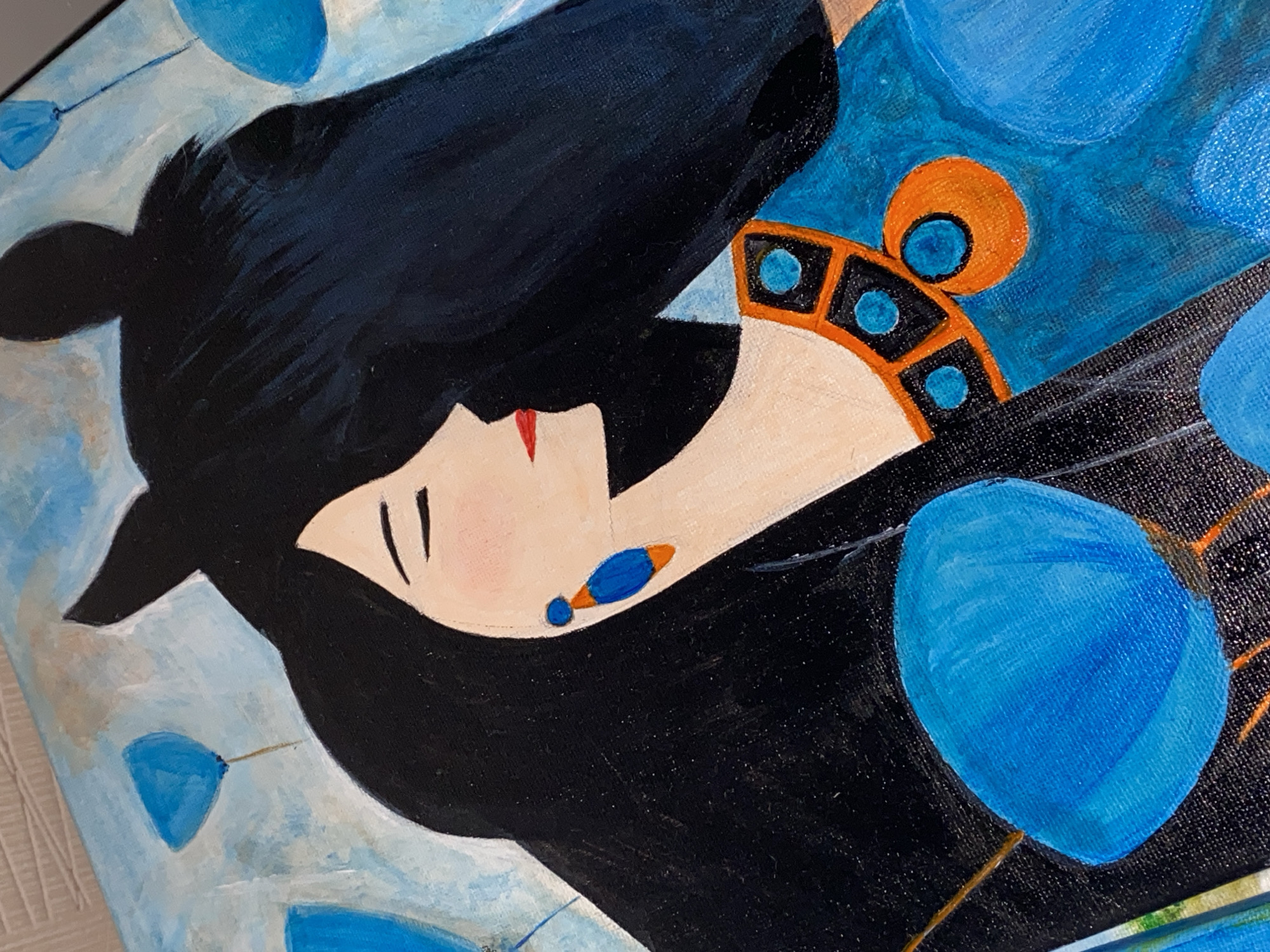 A close-up, tilted view of a painting depicts a woman with black hair, pale skin, and minimal facial features: a single black line for each eyebrow and a small red mark for the lips. She wears an orange and black headpiece adorned with blue circles, and a matching earring. The background is a light blue with abstract blue shapes resembling petals. There's no indication of Novokuznetsk, Russia in the image.