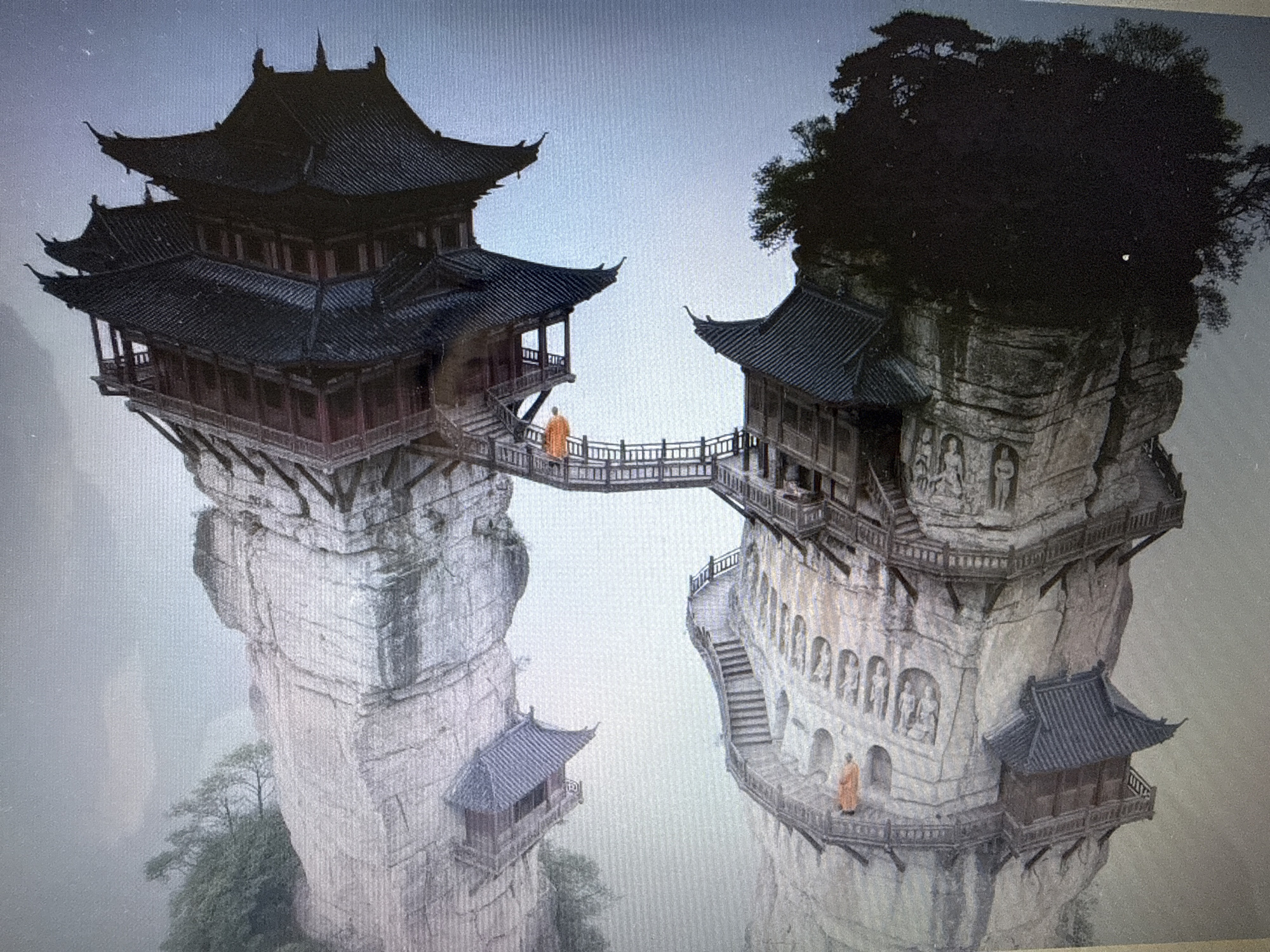 The image depicts two ancient Chinese-style temples perched precariously on the sides of two separate, towering rock formations, connected by a wooden bridge. On the left rock formation, a multi-tiered temple with dark, curved roofs dominates the summit. A smaller, single-story structure with a similar roof juts out from the cliff face below the main temple. On the right rock formation, another multi-tiered temple with dark, curved roofs sits atop the peak, surrounded by dense foliage. Carvings of figures are visible on the rock face below this temple. A wooden bridge spans the gap between the two rock formations. Two individuals, dressed in orange robes, are visible: one walking across the bridge, and another standing on a balcony of the right temple. The environment is misty and appears to be a mountainous or high-altitude region. There is no visible connection to the city of Pushkino, Russia in this image.