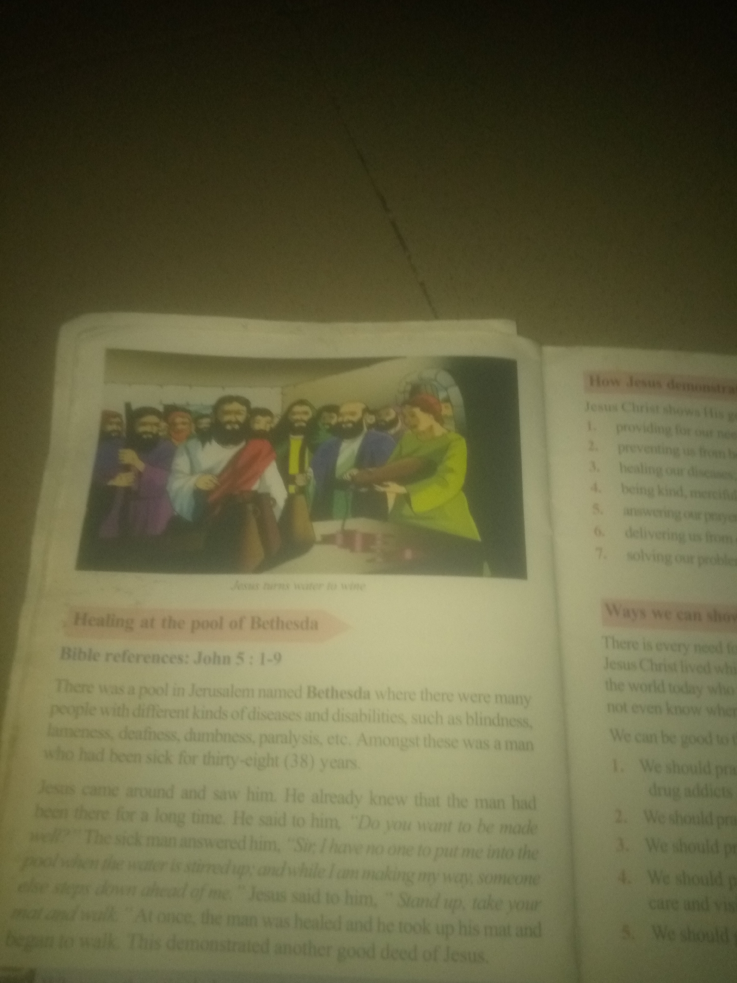 The image displays an open book with two pages visible. The left page features an illustration of Jesus Christ surrounded by people, with the caption "Jesus turns water to wine" below it. Above the illustration, there is a heading "Healing at the pool of Bethesda" and "Bible references: John 5: 1-9." Below the illustration is a paragraph of text describing the healing of a man at the pool of Bethesda. The right page has a heading "How Jesus demonstrates His go" followed by a numbered list. Below this list, another heading reads "Ways we can show" and then a paragraph and another numbered list. The text is in English, and the image quality is somewhat blurred. There is no information within the image that indicates a location in Jauro Yinu, Nigeria.