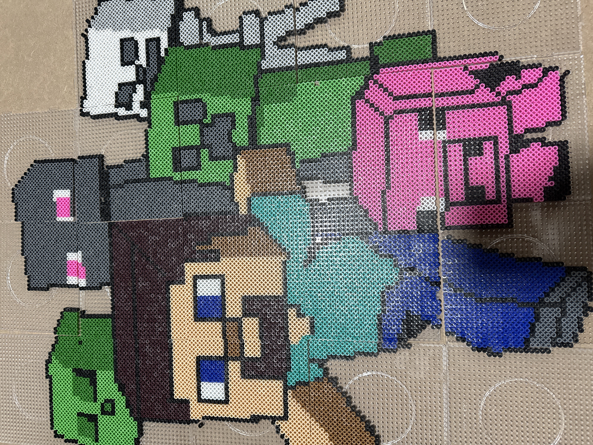 The image shows a fused bead creation of characters and objects arranged on a clear pegboard. From left to right and top to bottom, the figures are a white ghost-like creature, a green Creeper-like figure, a gray Enderman-like creature with pink eyes, a pink pig, a player character with brown hair and a teal shirt, and blue pants. The beads are various colors and create a pixelated appearance. The surface beneath the pegboard is a light brown color.