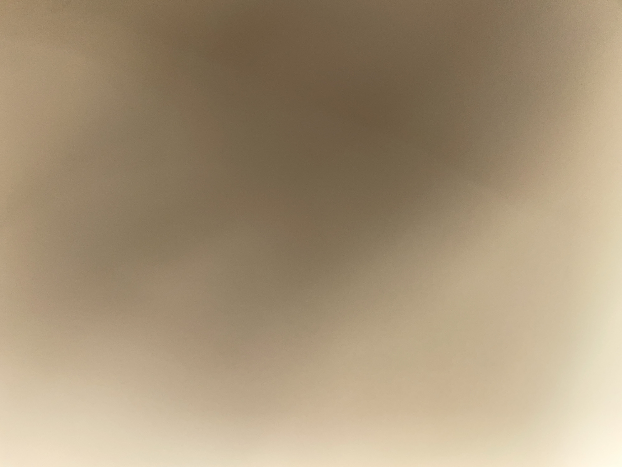 The image shows a blurred background with a gradient of light brown and cream colors. There are no discernable objects, people, or actions. The image lacks any specific details that would allow for identification of a location in Ilorin, Nigeria, or any other city. The overall impression is of an abstract or out-of-focus photograph.