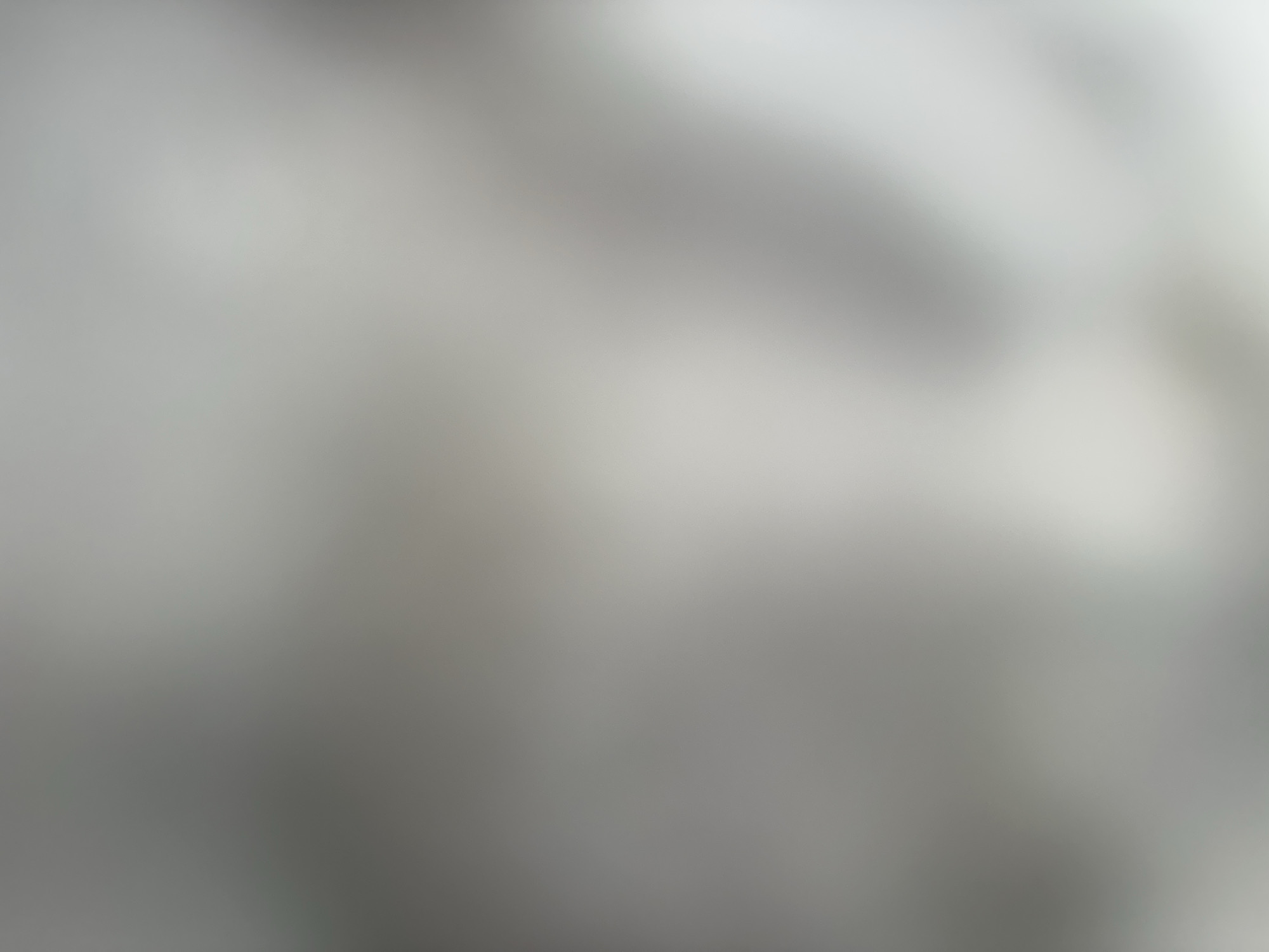 The image is a blurred, abstract shot of a textured surface, possibly fabric or a wall, with shades of gray and white. There are no discernible objects, people, or actions. The image's lack of detail and abstract nature make it impossible to determine its location in Belgrade, Serbia, or any other specific context.