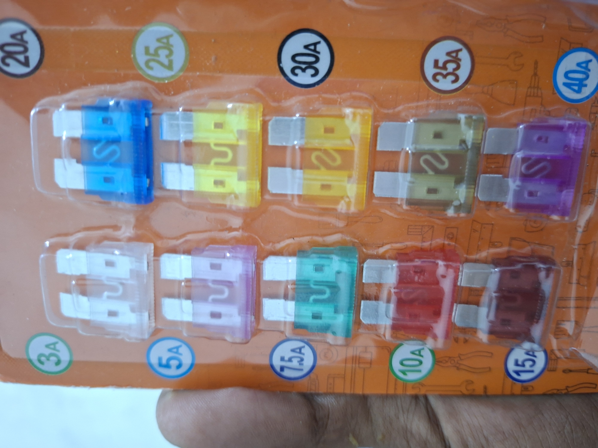 The image shows a package of automotive blade fuses of varying amperage. The fuses are arranged in two rows on an orange blister pack with amperage ratings labeled above each fuse (20A, 25A, 30A, 35A, 40A) and below each fuse (3A, 5A, 7.5A, 10A, 15A). The fuses are color-coded according to their amperage.
There is no location information from the image.