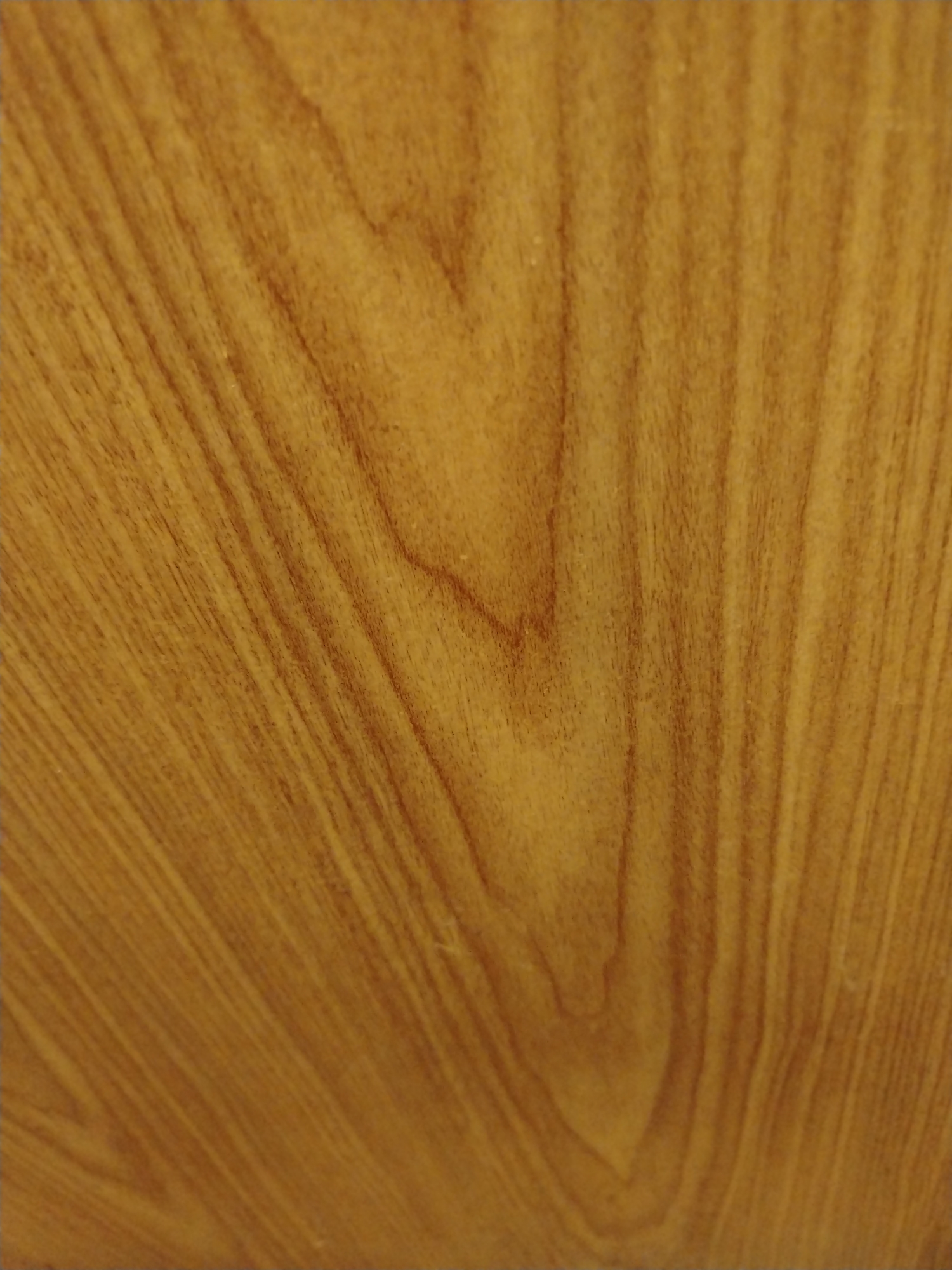 The image is a close-up, abstract view of a light brown wooden surface. The wood grain runs in wavy, vertical lines, with darker brown lines forming patterns within the lighter brown background. There are no people, objects, or any discernible features that would indicate a specific location, including the city of Yerevan, Armenia. The image appears to be a textural study of wood.