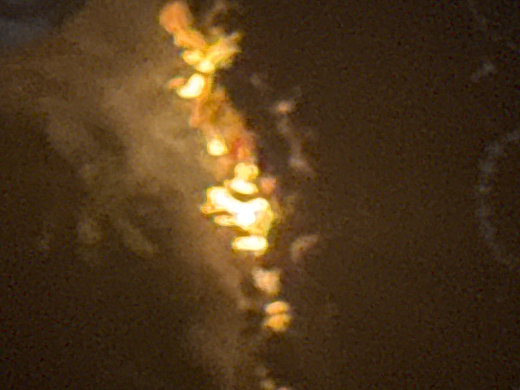 A blurry photograph appears to show lights reflected on a surface, possibly water. The lights are a bright yellow-orange color and are arranged in a vertical, somewhat linear fashion. The surrounding area is a dark, muted brown. No people, distinct objects, actions, or interactions are discernible. No specific information identifying the location as Ihiagwa, Nigeria, is evident in the image.