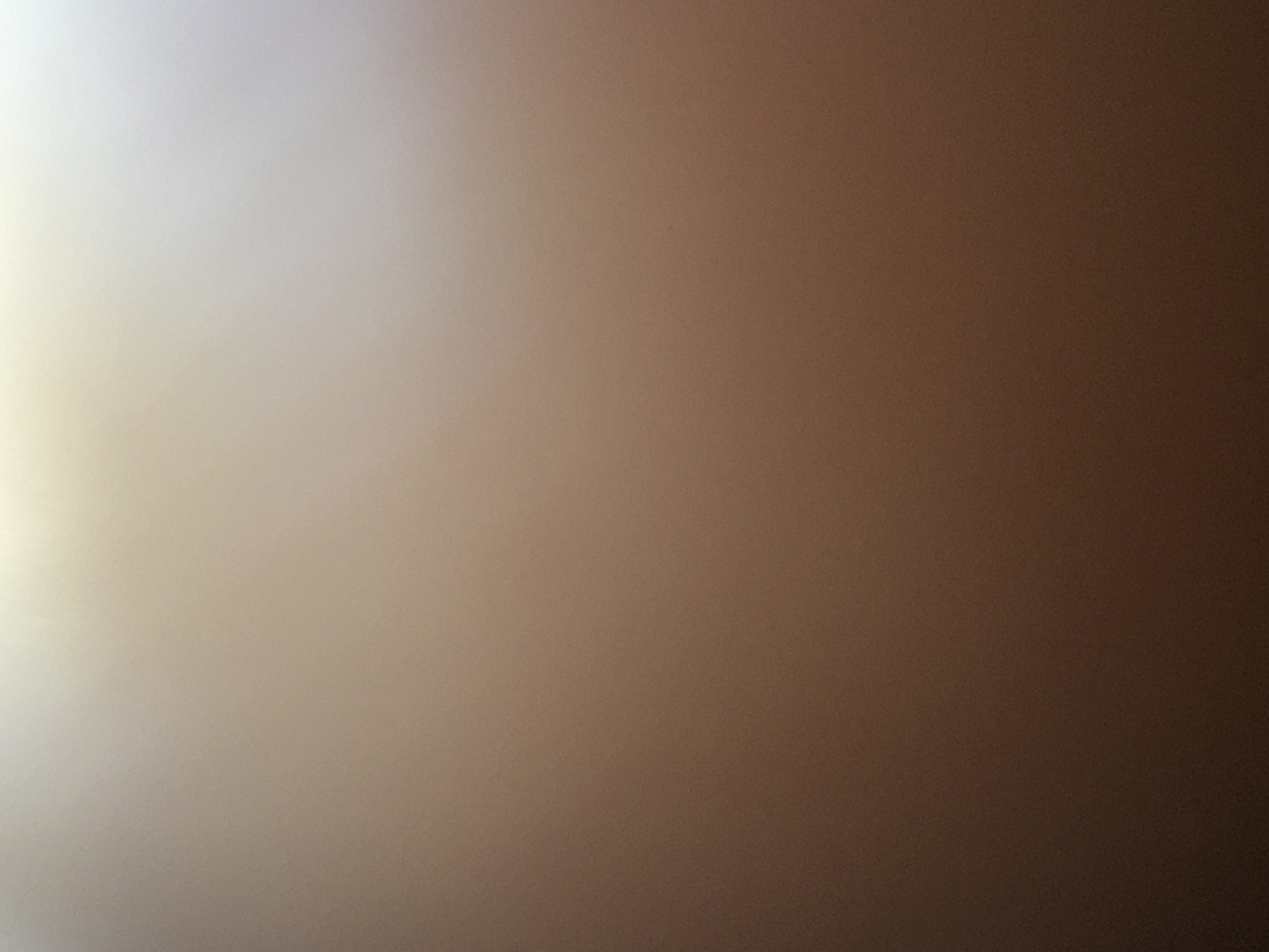 The image is a gradient of color ranging from light beige to dark brown. The light beige is concentrated on the left side of the image, gradually transitioning into a medium brown in the center and then to a dark brown on the right side. There are no discernible objects, people, or landmarks present. Location in Kuta Selatan, Indonesia cannot be determined from the visual information.