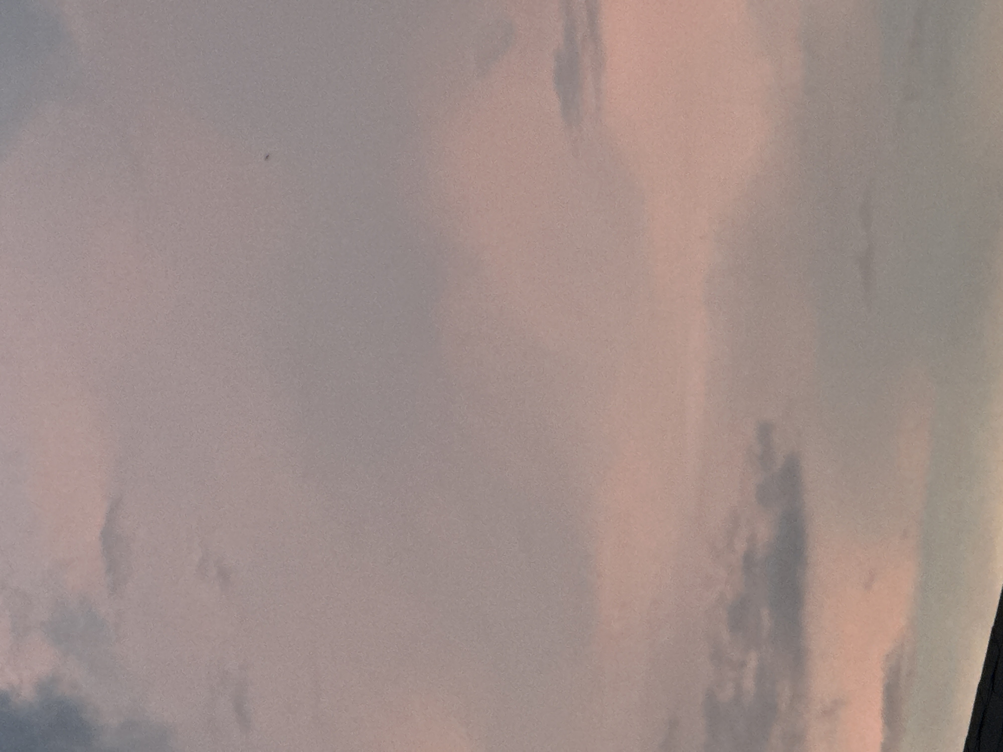 The image shows a sky with clouds. The clouds appear to be various shades of white, gray, and pink. The light seems to be coming from the horizon, creating a soft, diffused glow. There are no visible people, objects, or specific environmental indicators that would suggest a location in Nizhny Novgorod, Russia.