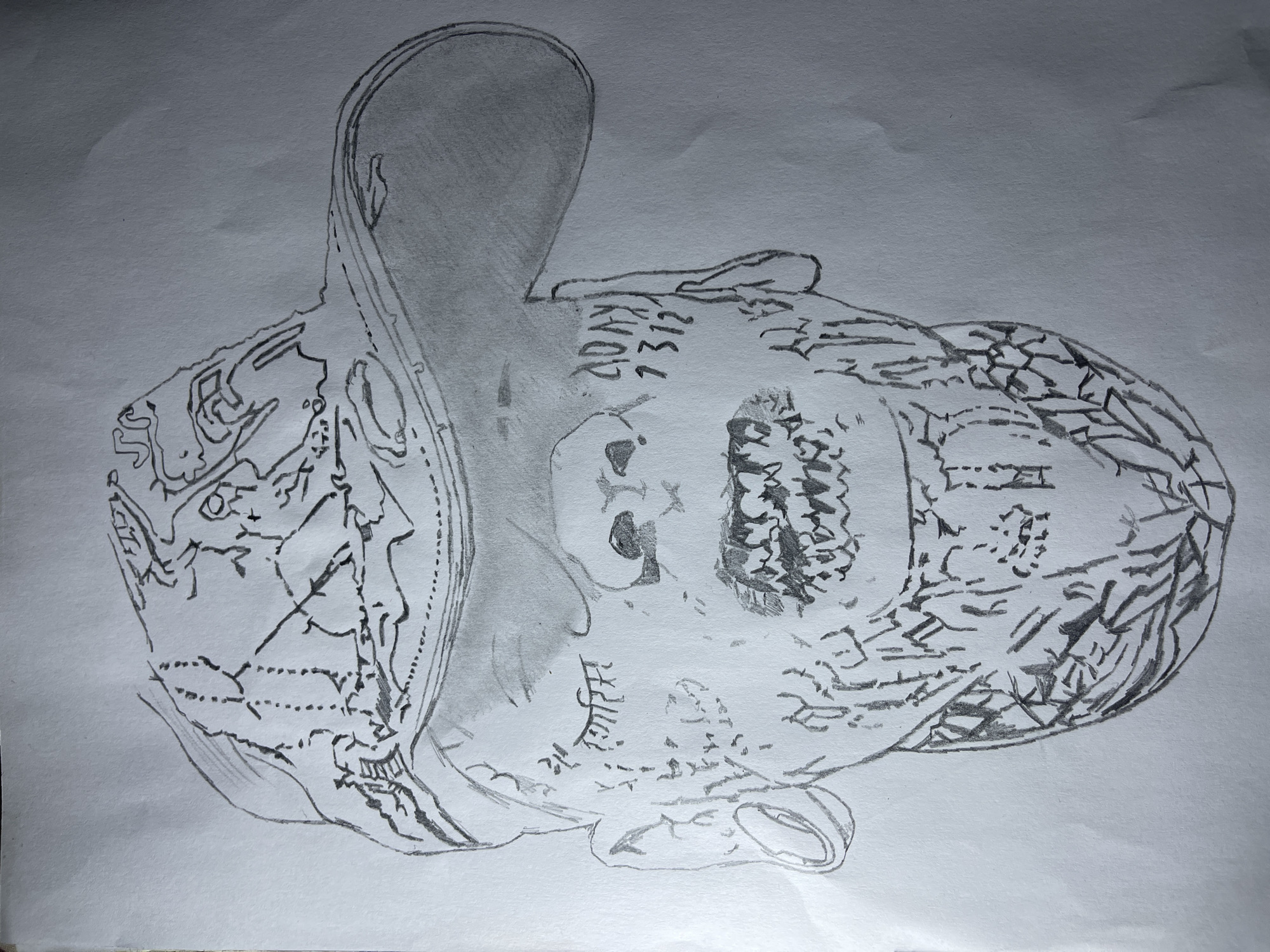 A grayscale pencil drawing on white paper depicts a face with intricate designs and details. The face has a skull-like appearance around the eye and nose areas. There are symbols and markings around the eyes, mouth, and cheek area. The hair or head covering appears to be detailed with feather-like strokes and geometric patterns. Part of the drawing features denser shading, while other parts are defined by line art. The environment and context are not depicted beyond the face itself. There is no information in the drawing that specifies the location as Jos, Nigeria.