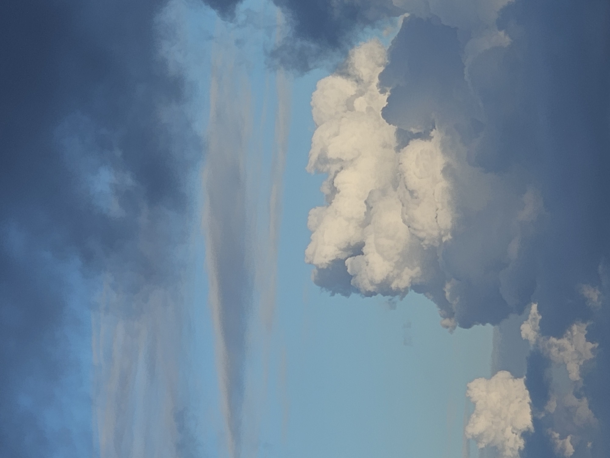 The image displays a sky filled with clouds of varying densities and colors, ranging from bright white to dark gray and blue. The lighting suggests it could be late afternoon or early morning. There are no visible people, subjects, objects, actions, or interactions depicted. The scene is an outdoor environment, specifically a sky with clouds. No specific landmarks or details within the city of Denpasar, Indonesia, are identifiable in this image.