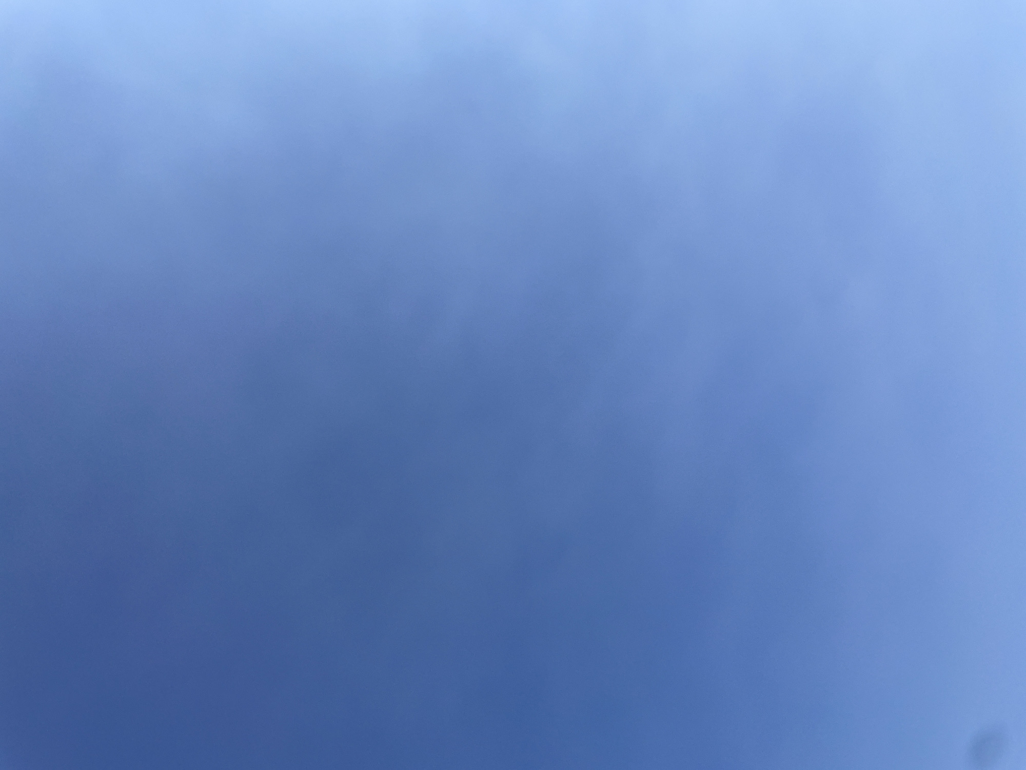 The image shows a clear blue sky with a slight gradient of lighter blue towards the right side. There are very faint, wispy clouds visible, particularly in the upper right quadrant. No people, objects, or buildings are visible. The scene is entirely comprised of the sky. Based on the information provided, this image could have been taken from anywhere in the city of Sevilla, Spain, as it depicts only the sky.