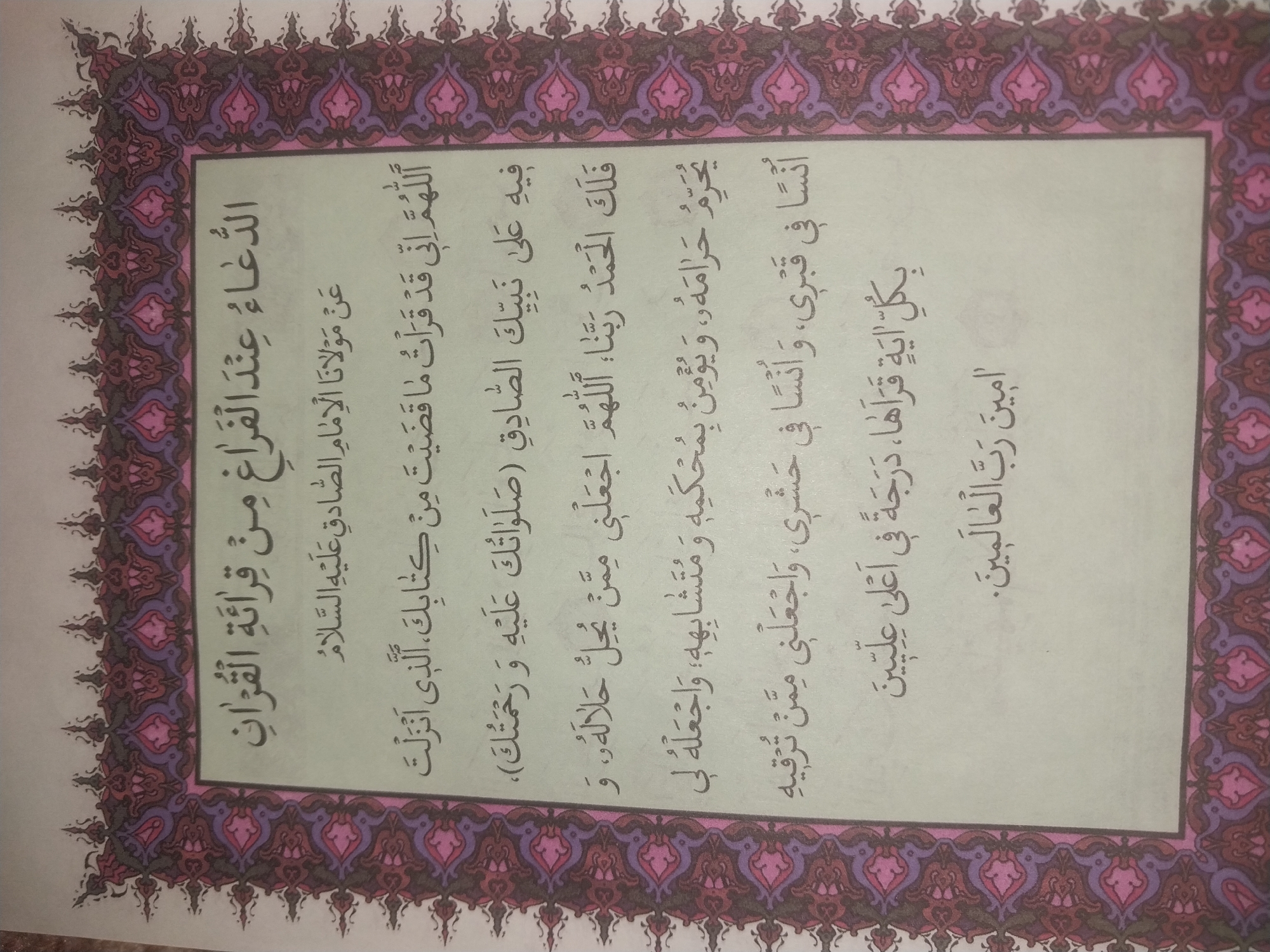 The image shows a page from a book with Arabic text and decorative borders. The text appears to be a prayer. The decorative borders are intricate and colorful, with floral and geometric patterns in shades of purple, pink, and blue. There are no people or other objects visible in the image, and the environment is not depicted. The location of Blagoveshenka, Kyrgyzstan is not relevant to the content of the image.