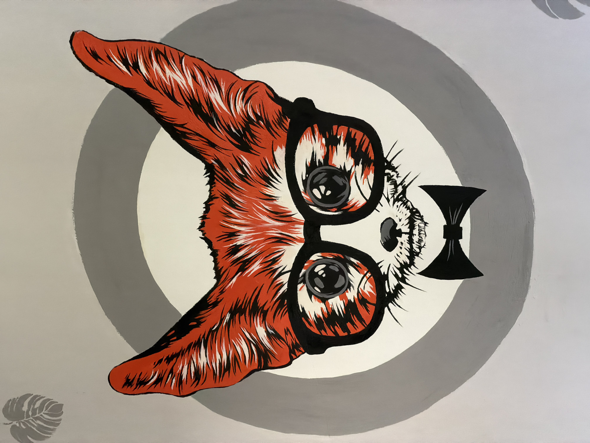 The image is a painting of a stylized fox's face. The fox has large, pointed ears with bright orange fur and black and white stripes. It is wearing thick-rimmed black glasses and a black bow tie. The background is a light gray with two concentric gray circles behind the fox's head. In the upper left corner, there is a faint silhouette of a monstera leaf. The painting is done in a graphic, bold style with sharp lines and vibrant colors. There are no people or any specific landmarks identifiable in the image to suggest a location in Chaikovsky, Russia. The painting appears to be a piece of art, possibly a mural or a canvas painting, and its context within the city of Chaikovsky is not discernible from the image itself.