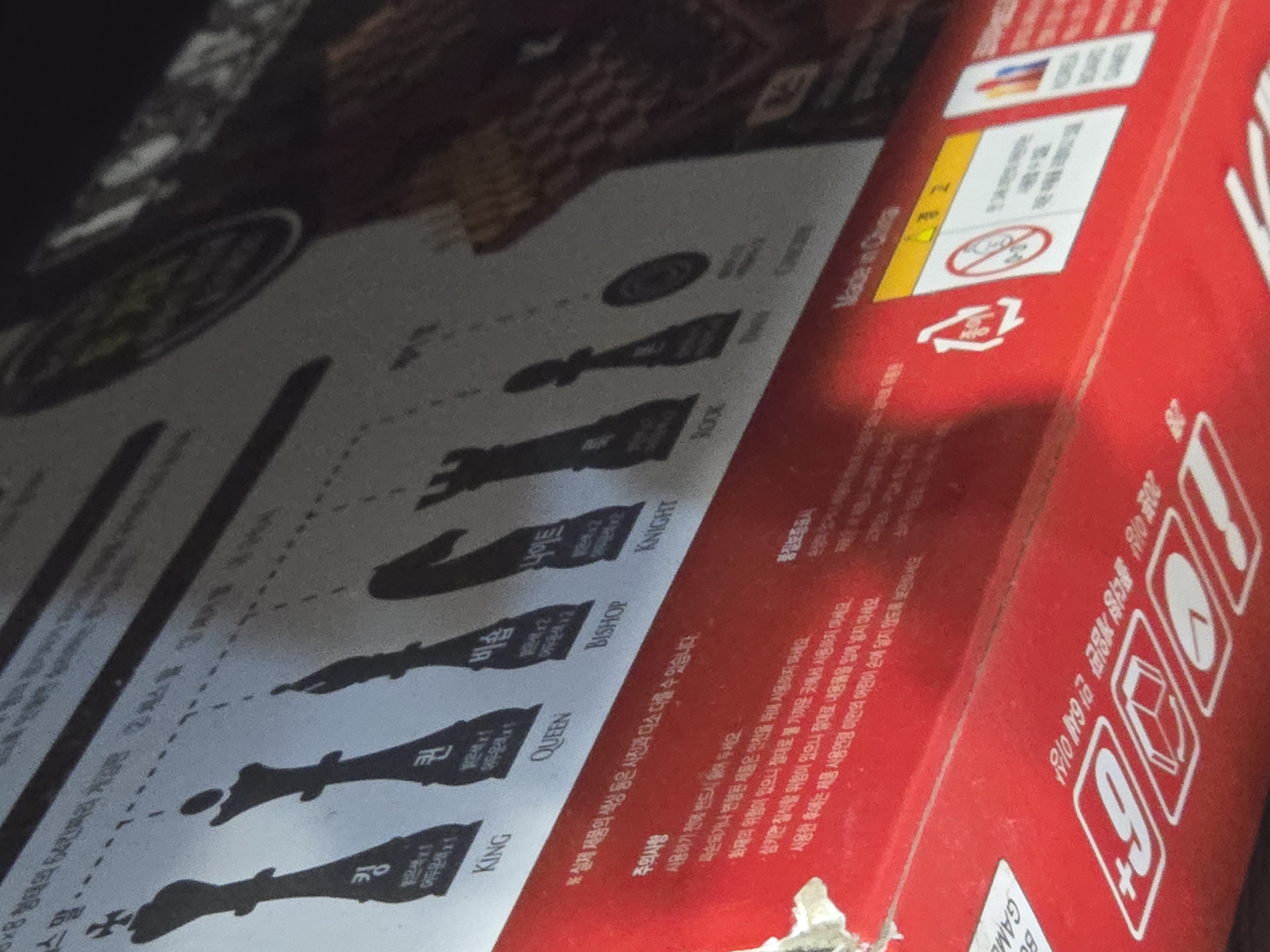 The image shows a red box, possibly for a board game, with text in Korean and some graphical elements. The box appears to be lying on a surface, and the lighting suggests an indoor environment. There are no visible landmarks or contextual clues to indicate a location in Ulan-Ude, Russia. The image is a close-up of the box and does not contain any people or actions.