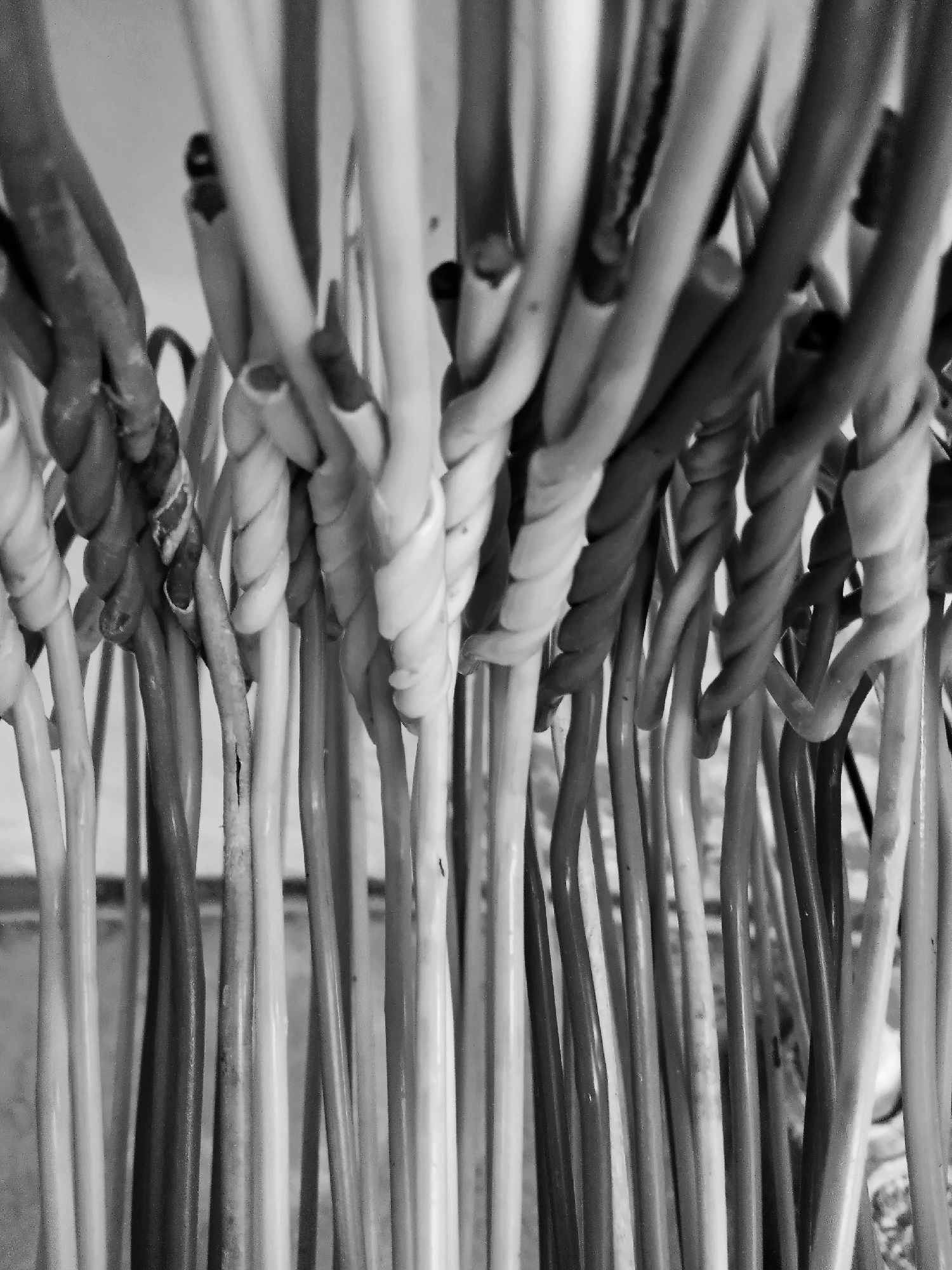 A close-up, black and white photograph depicts a collection of slender, cylindrical objects, each with a spiraled or twisted top. The items are densely packed together, creating a visual texture of vertical lines and repeating twisted shapes. The background is out of focus, suggesting a shallow depth of field. The lighting is even, revealing details in the shapes of the objects. There are no people, subjects, or interactions visible in the image. The photograph provides no indications of a location in the city of Montalbán, Venezuela.