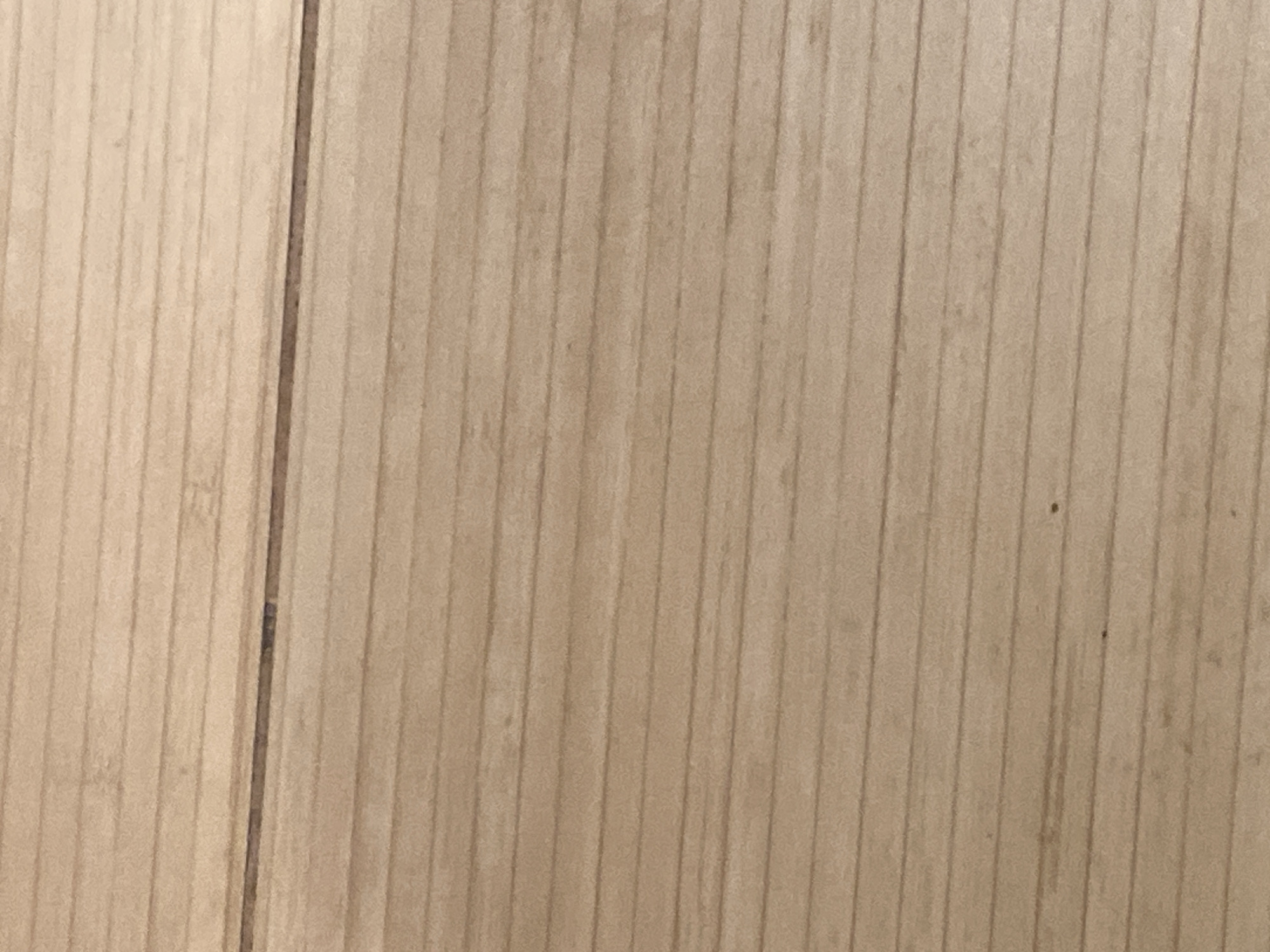 The image shows a close-up of a light brown wooden surface with vertical grain. The wood appears to be planks or strips laid side by side, with slight gaps between them. The lighting is relatively even, and the surface has a smooth, possibly polished appearance. There is no indication of the location of the image in Sofia, Bulgaria. The image contains no people, objects, actions, or interactions that would suggest location or relevance. The subject is purely a wooden surface.