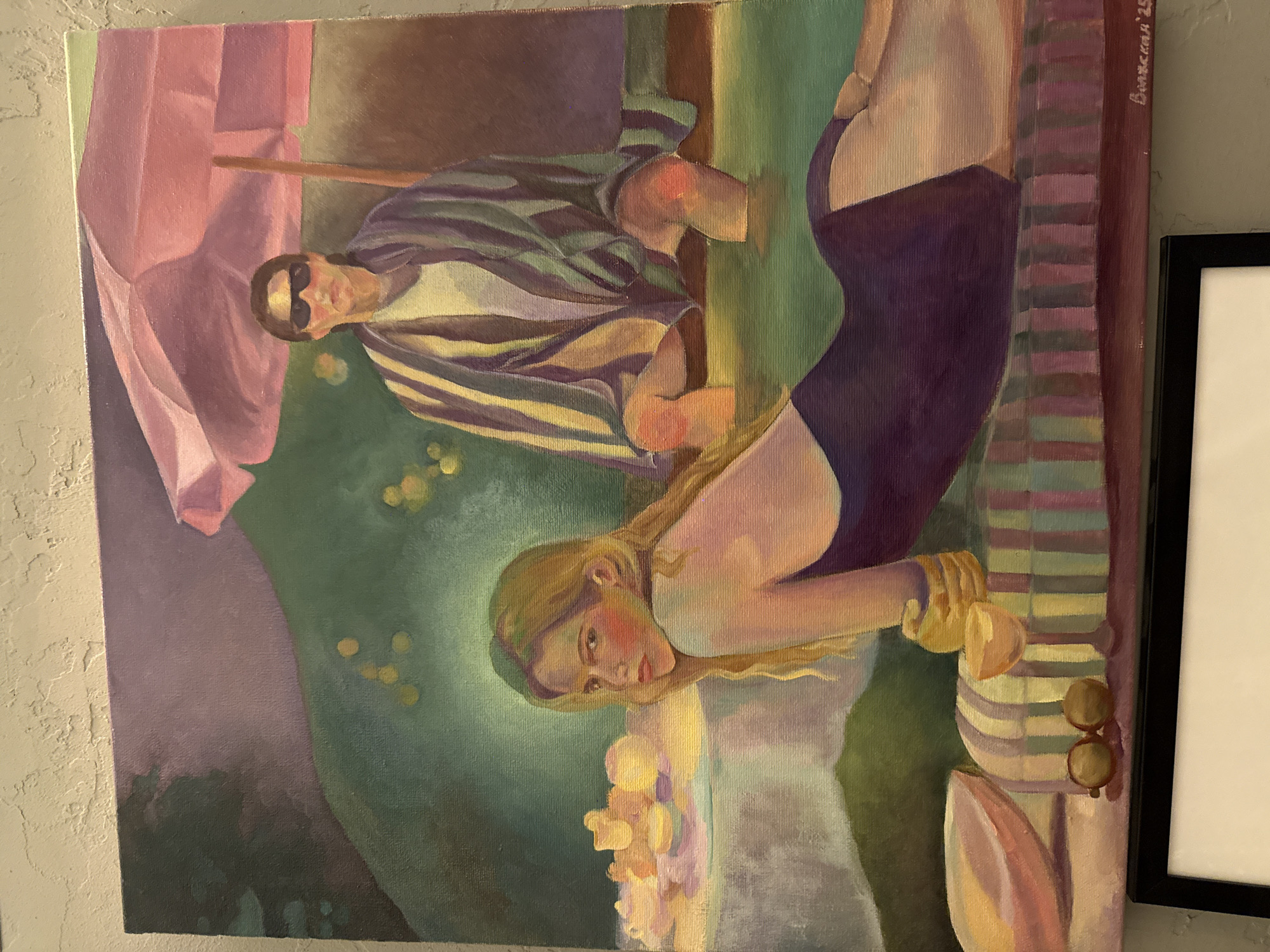 This painting depicts two figures enjoying a leisurely outdoor scene, with the provided image showing the artwork rotated 90 degrees clockwise.
In the foreground, a blonde woman with fair skin and rosy cheeks reclines, looking directly at the viewer with a captivating and slightly wistful gaze. She is dressed in a dark purple swimsuit or bodysuit, and her long hair cascades around her. Her left hand appears to be resting on a light-colored object or surface, possibly indicating refreshments or accessories.
Behind her and to the left, a man is seated, characterized by his dark sunglasses and a vibrant, horizontally striped shirt featuring shades of green, purple, yellow, and beige. His posture suggests relaxation, with bent arms. A large pink umbrella is partially visible behind him on the far left, providing shade.
The background consists of lush green tones, interspersed with blurred yellow and white spots that evoke sunlight filtering through foliage or a soft bokeh effect. A striped blanket or towel, with colors similar to the man's shirt, lies beneath the woman and extends to the right. Small, round, brown objects, possibly a pair of sunglasses, rest on this striped surface near the woman's right arm.
The artwork is an oil painting on canvas, characterized by visible brushstrokes that contribute to its impressionistic quality. The overall color palette is soft and muted, creating a calm and serene atmosphere, suggestive of a pleasant summer afternoon. In the upper right corner of the canvas, Cyrillic text is visible, reading "Вишесский '23" (Vishcheskiy '23), likely indicating the artist's name and the year of creation as 2023.