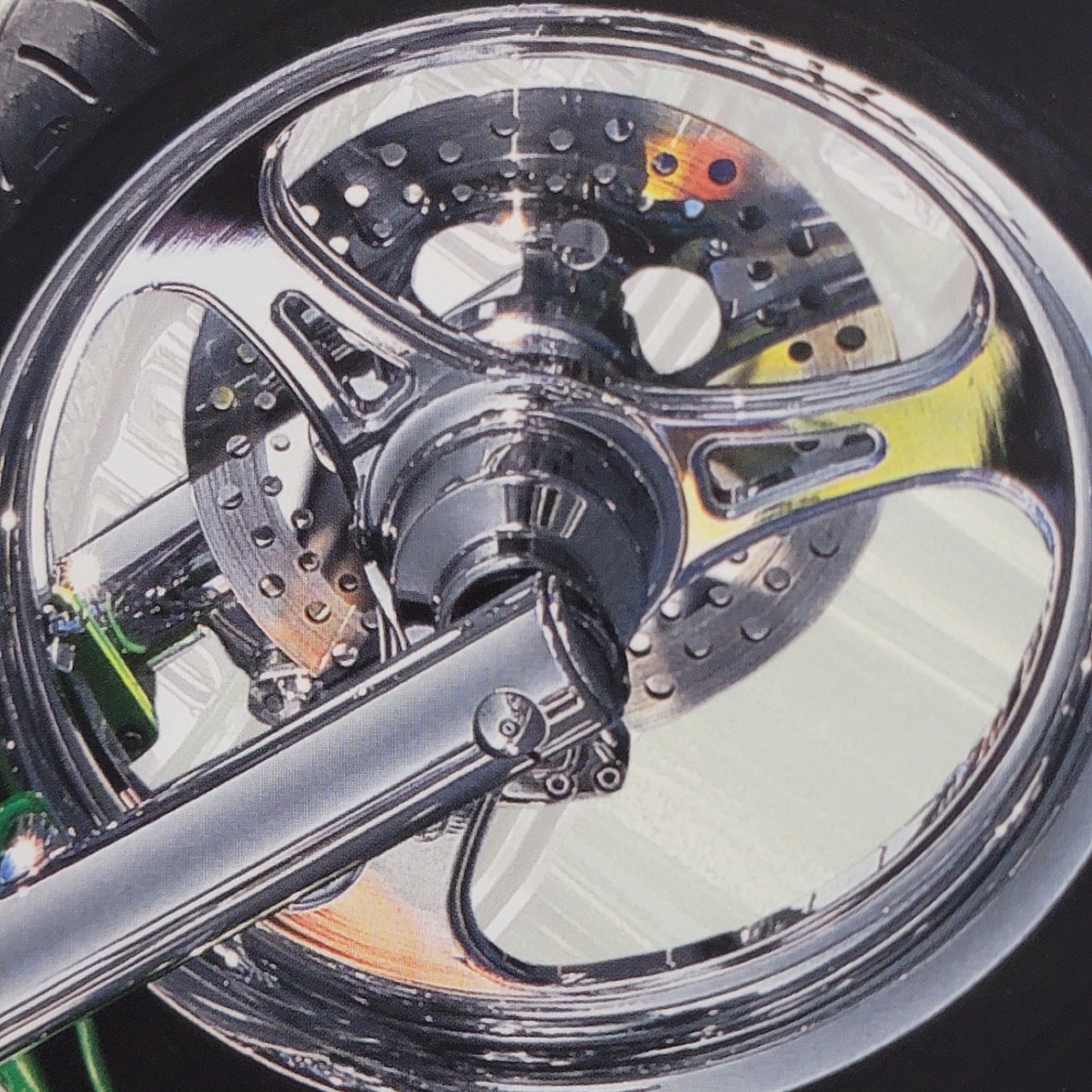 The image displays a close-up view of a motorcycle's chrome wheel and brake assembly. The wheel is highly polished and reflective, showing a complex, multi-spoke design with cut-outs. Visible within the wheel are the perforated brake rotor and part of the brake caliper. A thick, chrome-plated fork leg is also prominently featured, extending diagonally across the frame. The tire itself is a dark, ribbed rubber.
The lighting suggests it might be daytime, with strong reflections indicating a bright environment, but the specific time of day and weather conditions are not discernible. There are no people visible in the image, and the setting is abstract, focusing entirely on the mechanical components. The colors are dominated by metallic silvers and grays, with hints of yellow and orange in the reflections and on the brake rotor, likely due to heat or a colored coating. The overall impression is one of intricate mechanical detail and a high-end aesthetic, emphasizing the polished surfaces and the engineering of the motorcycle part. No text is visible in the image.