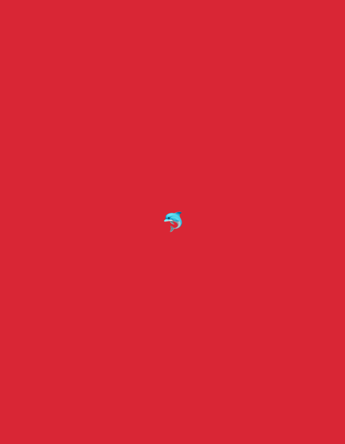 The image is a minimalist composition featuring a bright red background. Centered in the lower portion of the frame is a small, blue dolphin emoji. The dolphin is depicted in a playful, leaping pose, with its body arched and its tail fin angled upwards. The background is a solid, uniform red color, with no other objects or features visible. The image does not depict any specific location in the city of Burgas, Bulgaria.