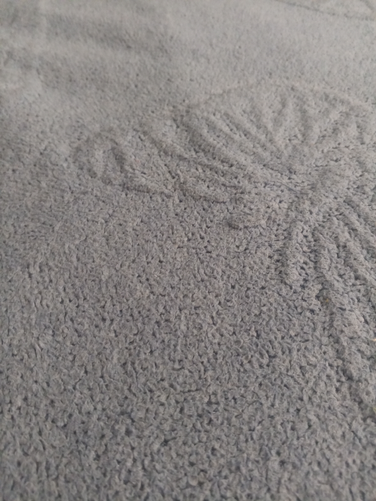 The image shows a close-up, abstract view of a gray, fluffy fabric surface. The texture is consistent throughout the image, with visible loops or piles of thread. There are no discernable objects, people, or actions within the frame. The image does not provide any information that would allow for its location to be identified as Novopokrovskaya, Russia, or any other specific geographical location.