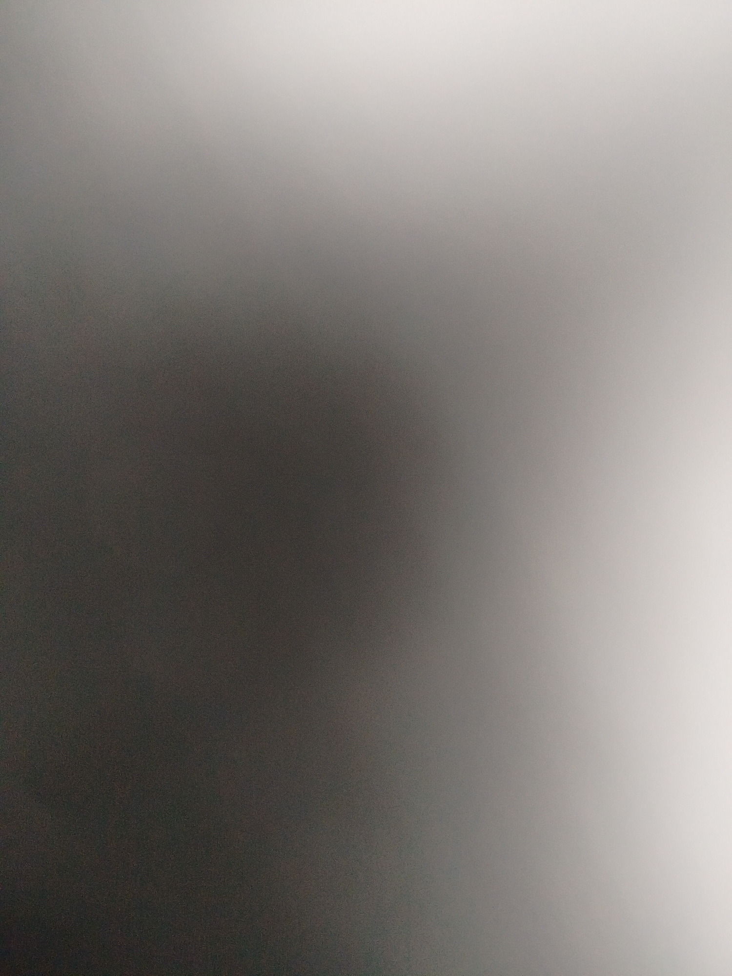 The image shows a blurry, gradient background transitioning from dark gray on the left to light gray/white on the right. There are no discernible objects, people, or specific environmental features to indicate it's in Yerevan, Armenia, or any other location. The image is out of focus.