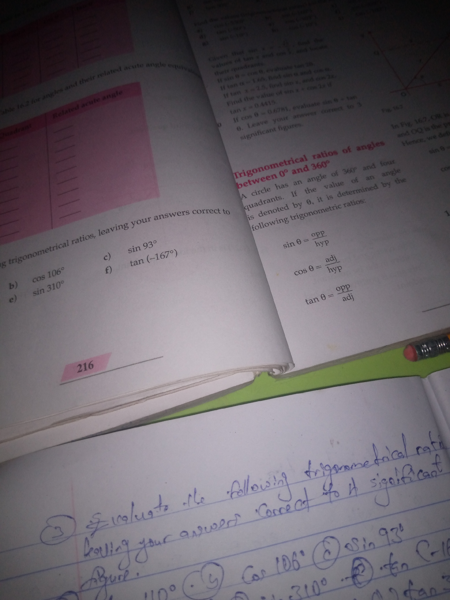 The image shows an open textbook with a notebook laid on top of it. The textbook contains mathematical content related to trigonometry, including tables, definitions, and formulas like sin θ = opp/hyp. There are also practice problems listed, such as "cos 106°", "sin 93°", and "tan (-167°)". The notebook, written in blue ink, contains handwritten notes that appear to be a continuation or solution to the textbook's problems, with phrases like "Evaluate to the following trigonometric ratios, leaving your answers correct to 4 significant figures". The page number "216" is visible on the textbook. The lighting suggests the image was taken indoors, possibly in a study or library setting.