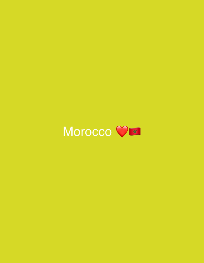 The image displays a digital graphic centered on a solid, vibrant yellow-green background. The graphic consists of the white text "Morocco," immediately followed by a solid red heart emoji, and then the national flag of Morocco emoji. No people, physical objects, or specific environmental features are depicted. The scene is a digital composition, with the graphic elements symmetrically positioned against the plain background. This graphic is associated with the city of Casablanca, Morocco.