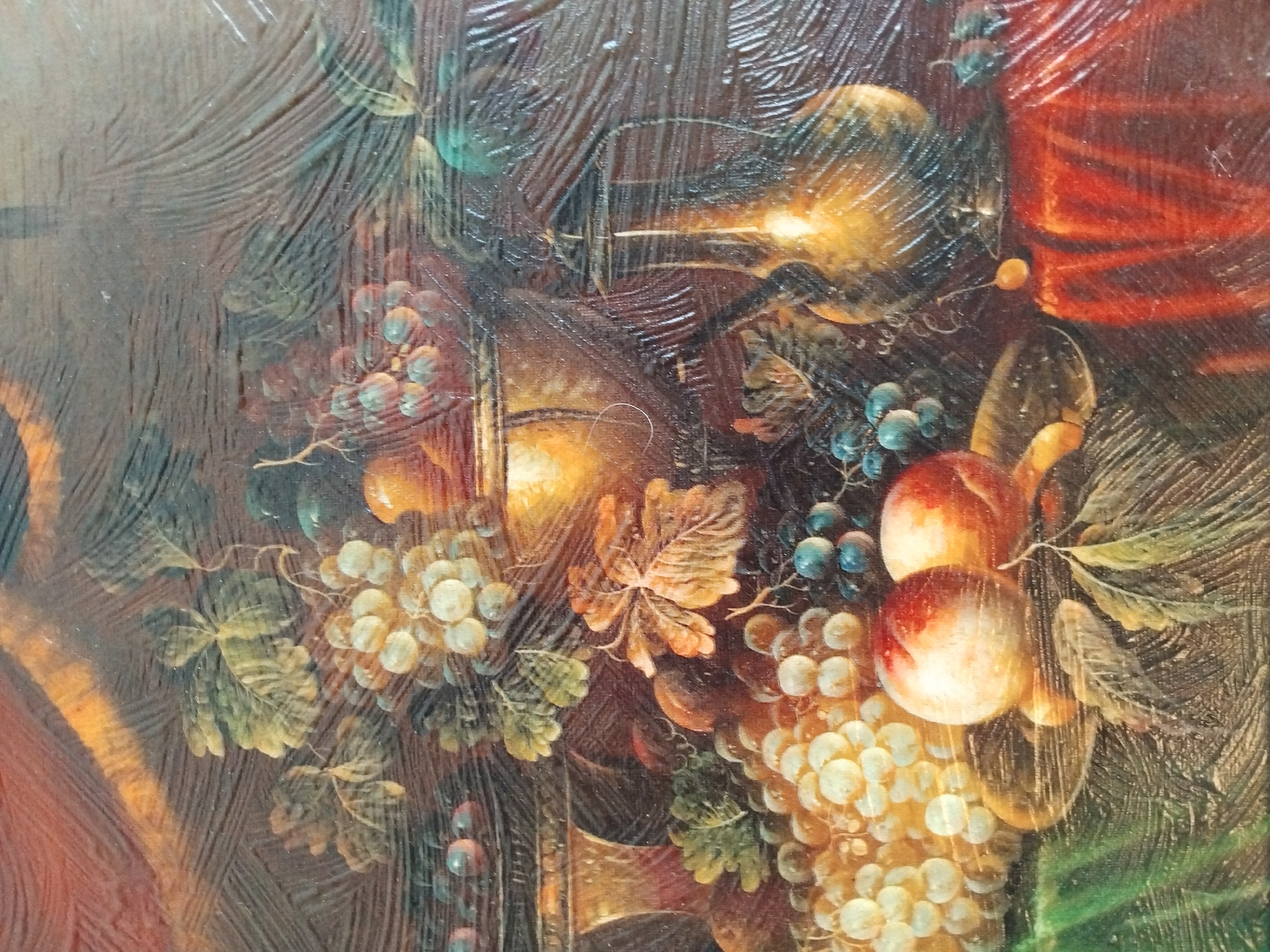 The image is a close-up, detailed photograph of a still life painting. The painting depicts a variety of fruits, including clusters of light-colored grapes and darker blue grapes, along with two peaches. There are also metallic vessels, one appearing to be a jug with a handle, and another broader urn-like object. The arrangement is set against a dark, textured background and draped fabric in shades of red and green. The overall style suggests a classical or baroque influence. The painting's surface exhibits visible brushstrokes and a glossy finish, possibly due to varnish. The photograph does not depict any specific location in Akhaltsikhe, Georgia; it is solely an image of artwork.