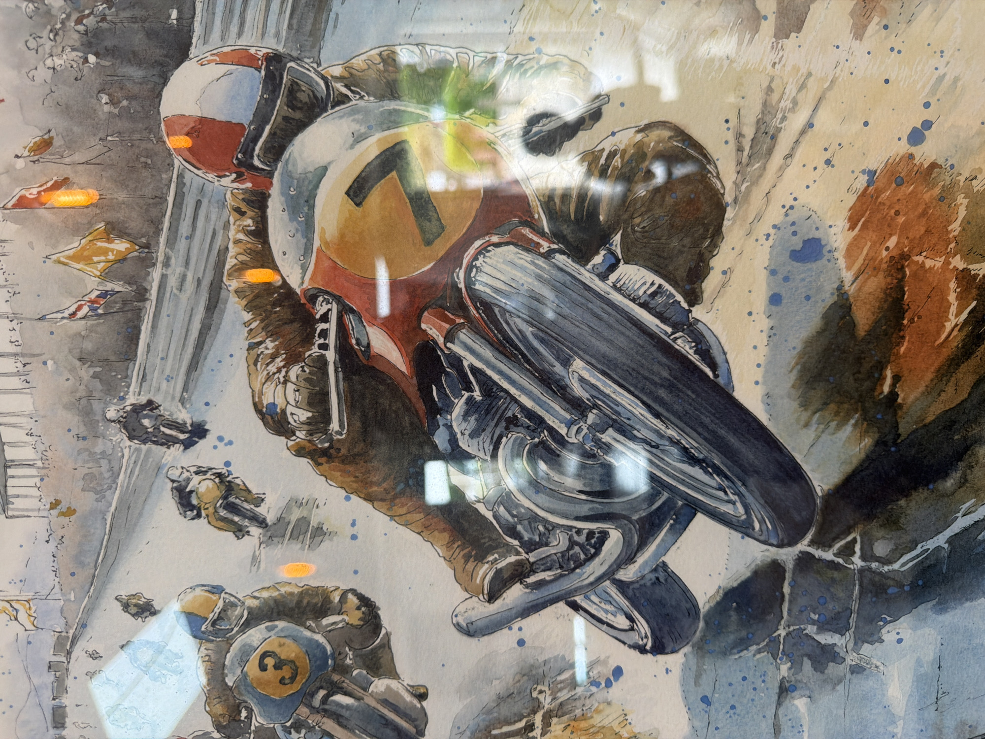 The image is an art piece depicting a motorcycle race. The primary subject is a motorcycle racer with the number 7 on their bike. Other motorcycles and racers are visible in the background, suggesting a race in progress. In the upper left, there are flags visible alongside what appears to be the raceway's boundary. The piece is done in a watercolor style, with loose strokes and splatters. The exact location within London is not explicitly depicted, but based on the racing context, it could potentially be related to a motorsport event or historical racing track.