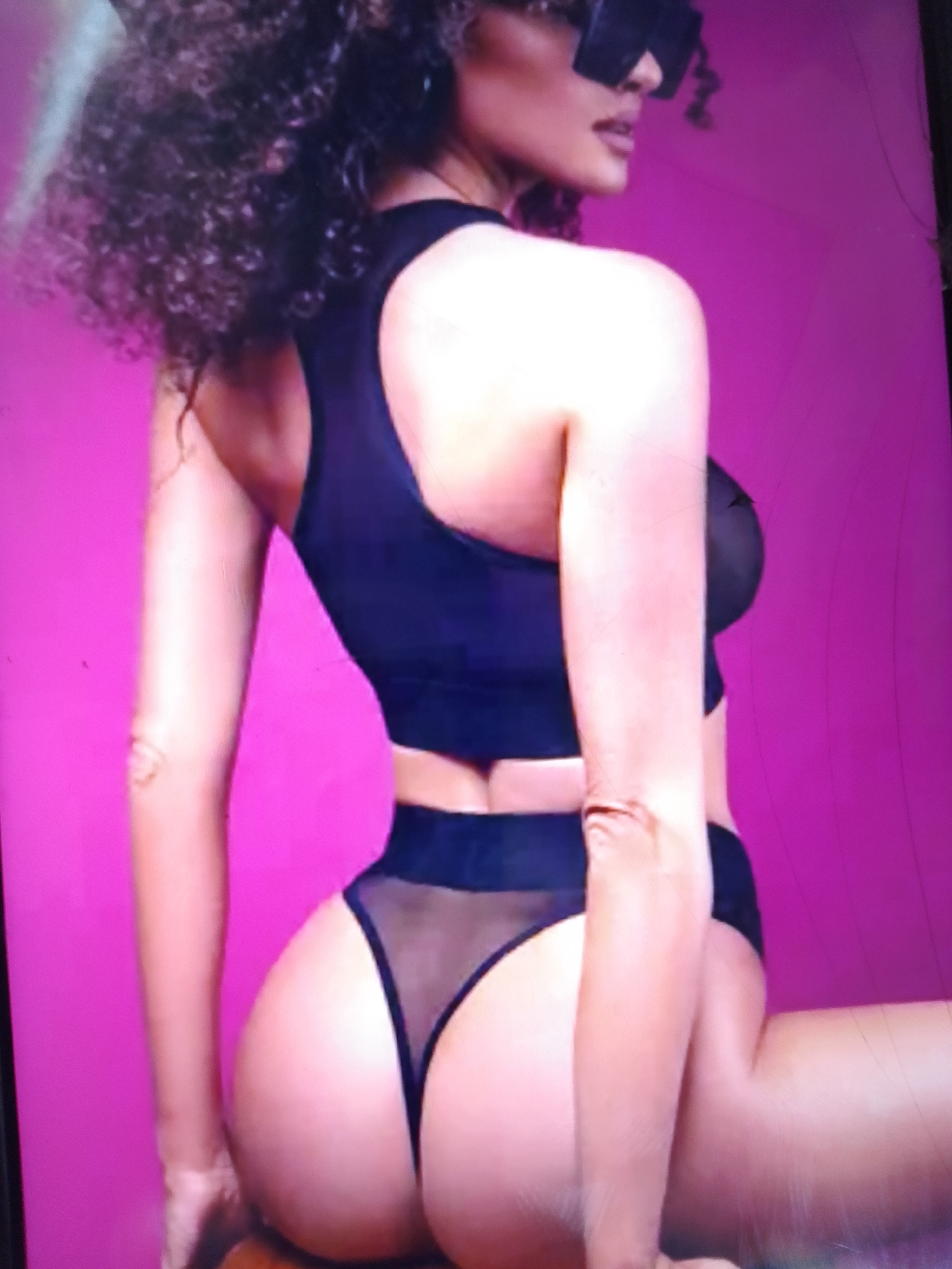 The image shows a person from the back, wearing a black bra and underwear. The background is a solid pink color. There are no visible elements that can place the scene in Dobra Krynytsia, Ukraine.