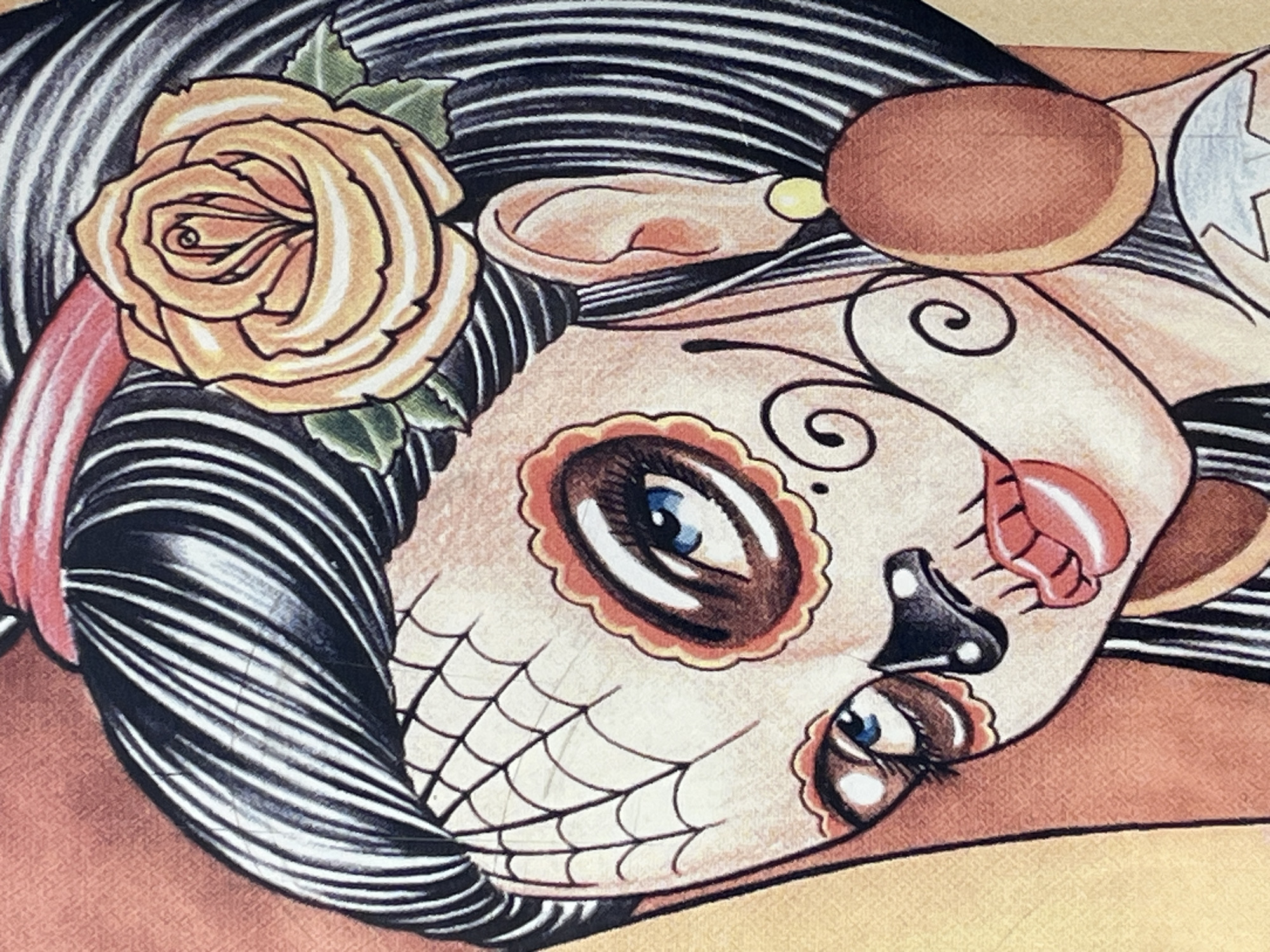 The image depicts a stylized drawing of a woman with "Day of the Dead" (Dia de los Muertos) style makeup. She has a large yellow rose with green leaves in her hair. Her hair is styled with black and white stripes. Her face is painted with decorative details including floral designs around her eyes, a web-like pattern on her chin, and accents around her lips. The woman is depicted against a peach-colored background. There is no information provided in the image that indicates its location in Varna, Bulgaria.