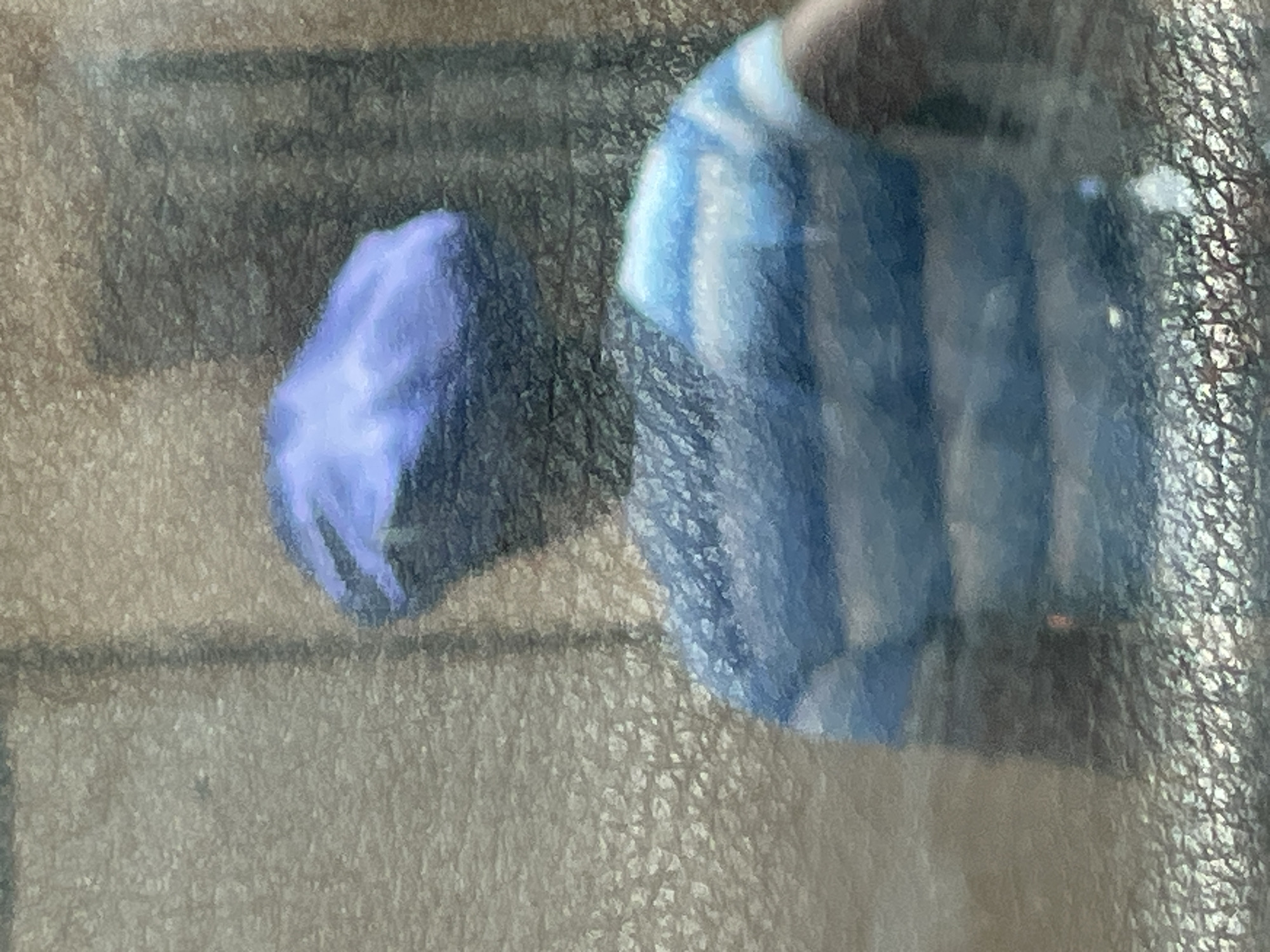 The image depicts two objects on a textured surface, likely a car dashboard. On the left, there is a crumpled blue object, possibly a piece of fabric or a disposable glove. To the right, there is another object with blue and white vertical stripes, potentially a folded shirt or a face mask. The image quality is somewhat unclear due to reflections on the surface. The location in the city of Jos, Nigeria, is not determinable from the image alone. There is no indication of people, actions, or interactions in this image.
