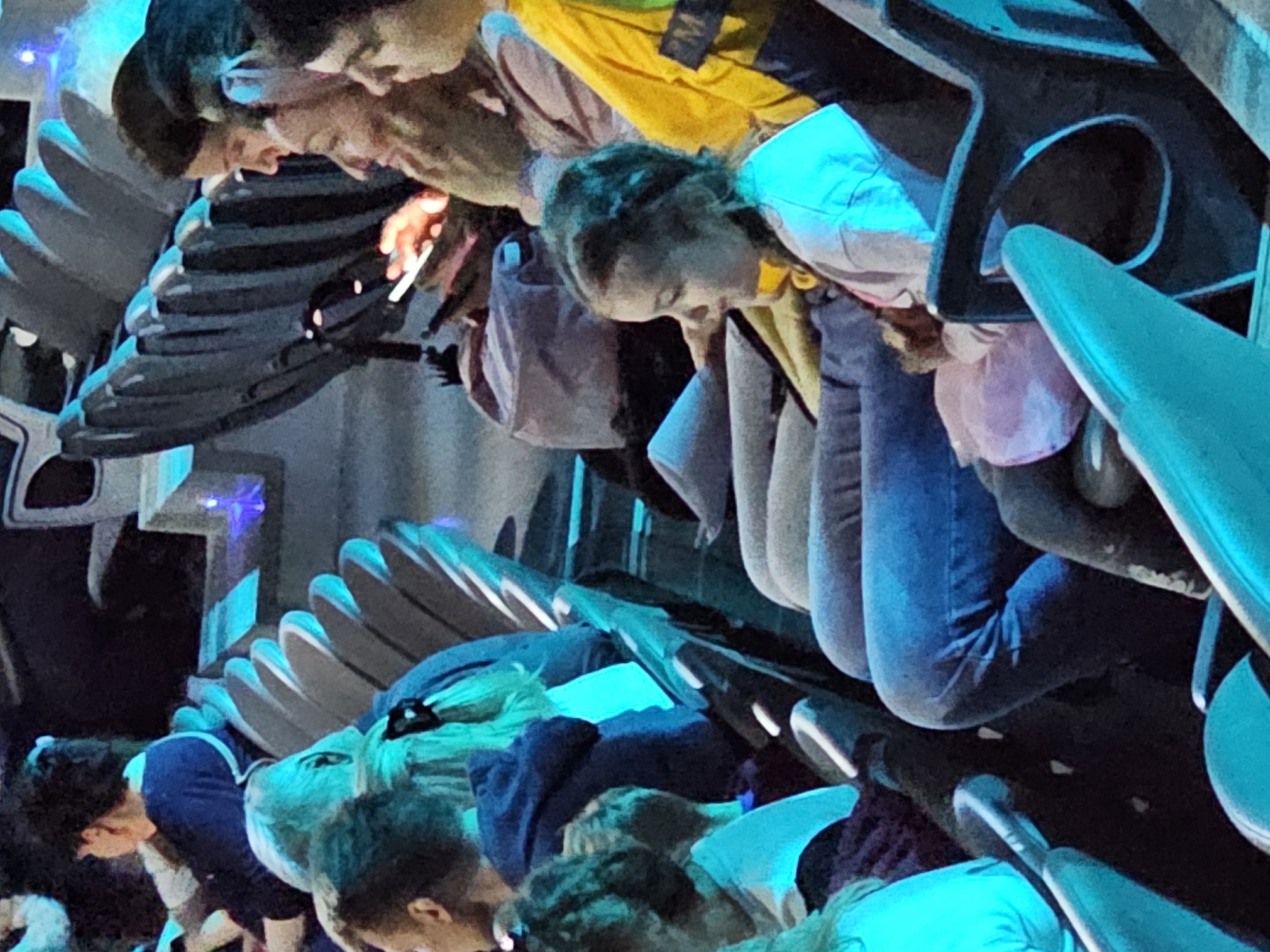 The image shows several people seated in a dark, illuminated environment that is suggestive of an immersive experience, potentially in a theatre or ride. The seating appears to be modern, possibly part of a 4D attraction with moving seats. The people are looking forward, potentially watching a show or partaking in a simulator ride. It is not possible to determine if the location is in Moscow, Russia, or any other specific location.